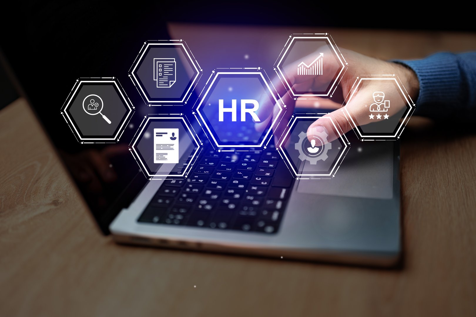 A person interacts with a laptop, highlighting various human resources management concepts. The setting is a contemporary office environment during a busy workday.