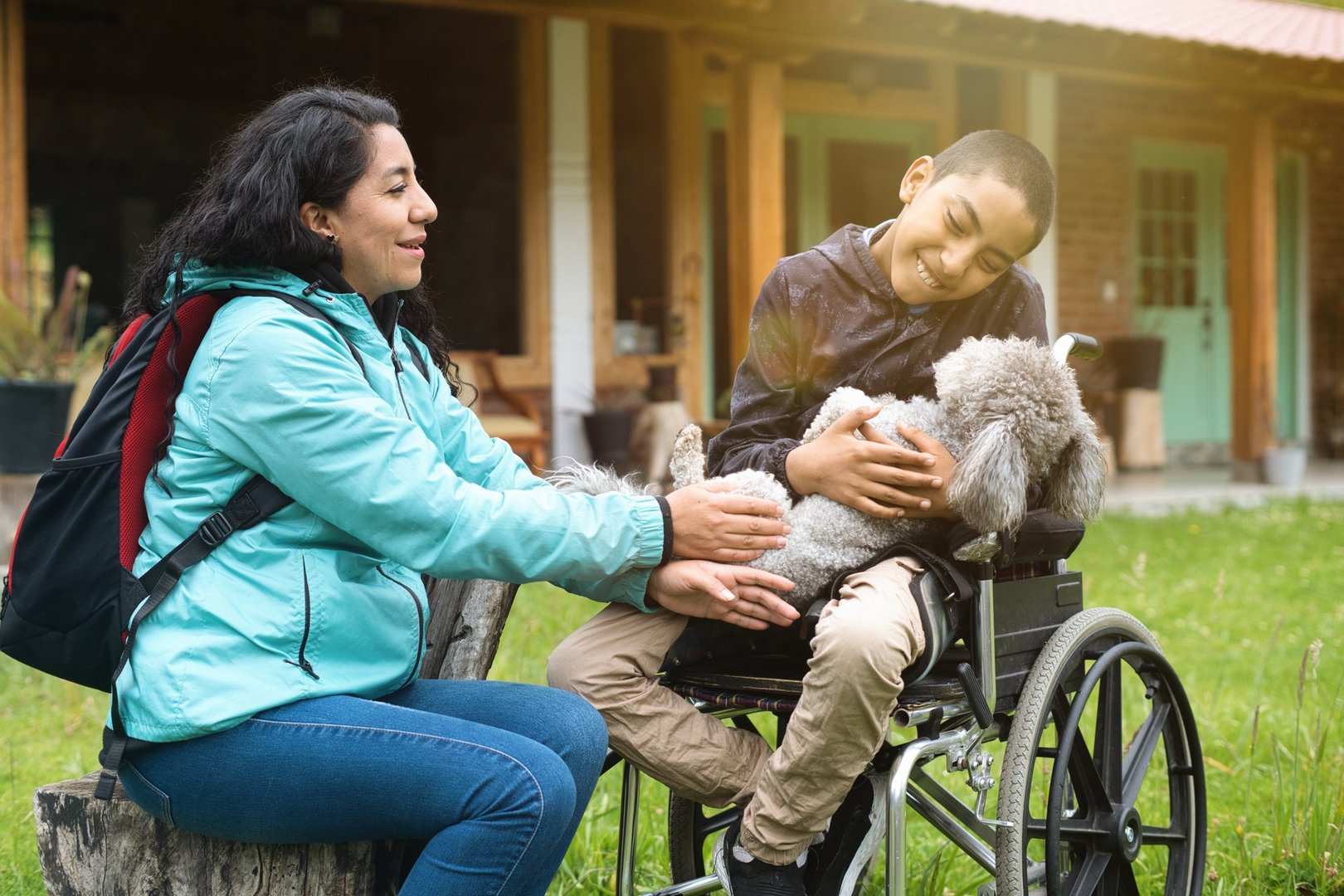Capturing a joyful moment of inclusive tourism, a mother and her son in a wheelchair share quality time with their pet dog in a serene outdoor setting
