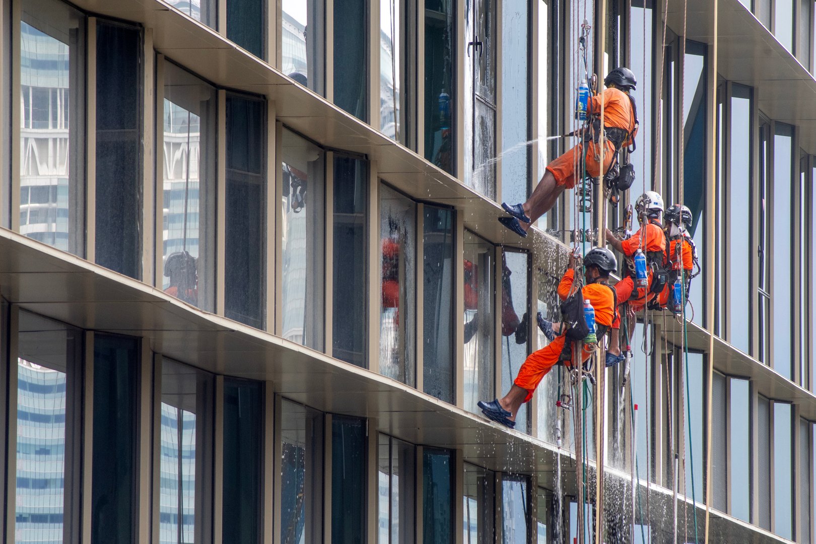Singapore- 27 Sep 2025: Workers are cleaning the glass wall of an office building in Singapore