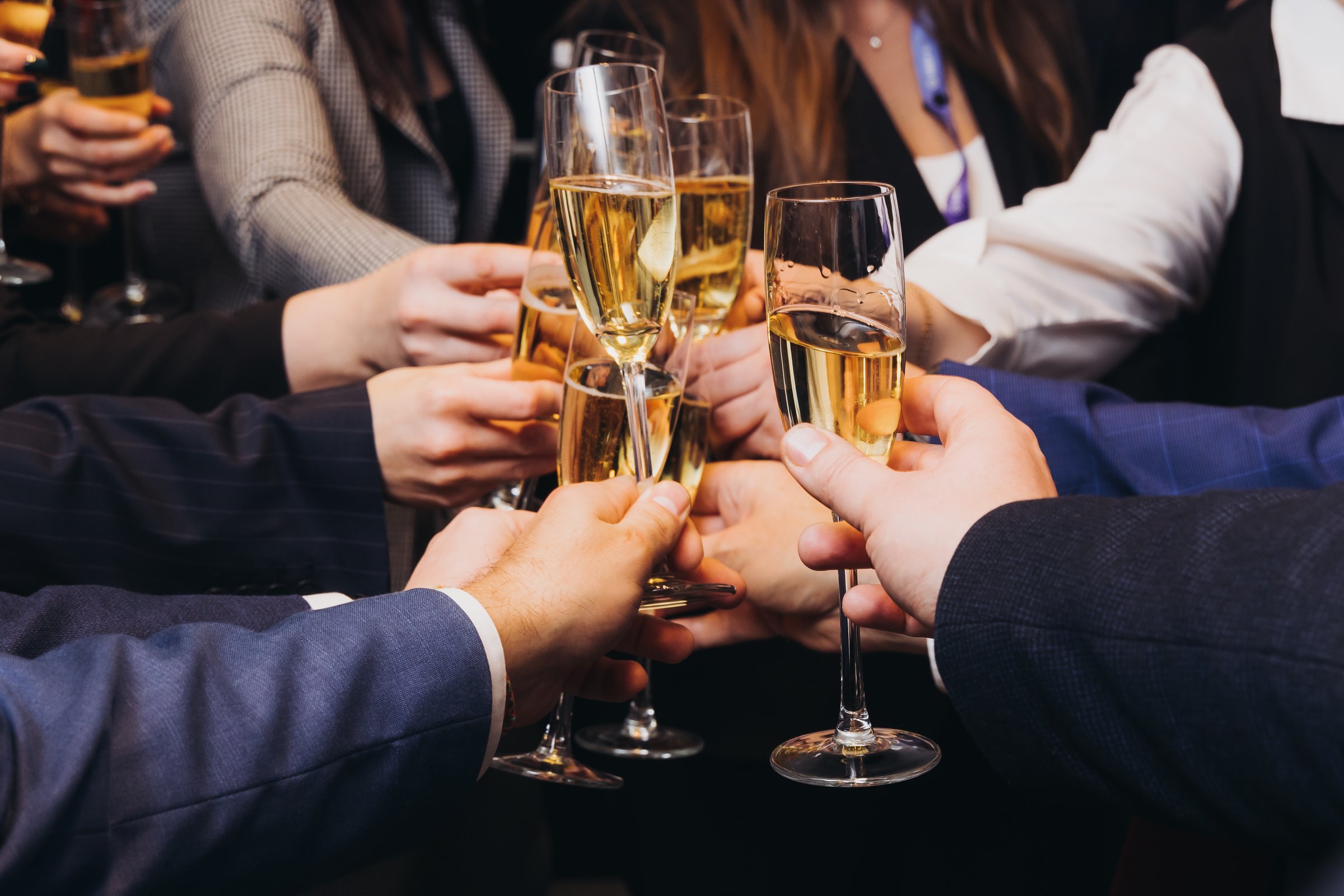 Group of businessmen celebrate, closing successful concluded deal, guests clinking raise glasses with alcohol, sparkling wine, toasting and cheering, colleagues team in office on corporate party event