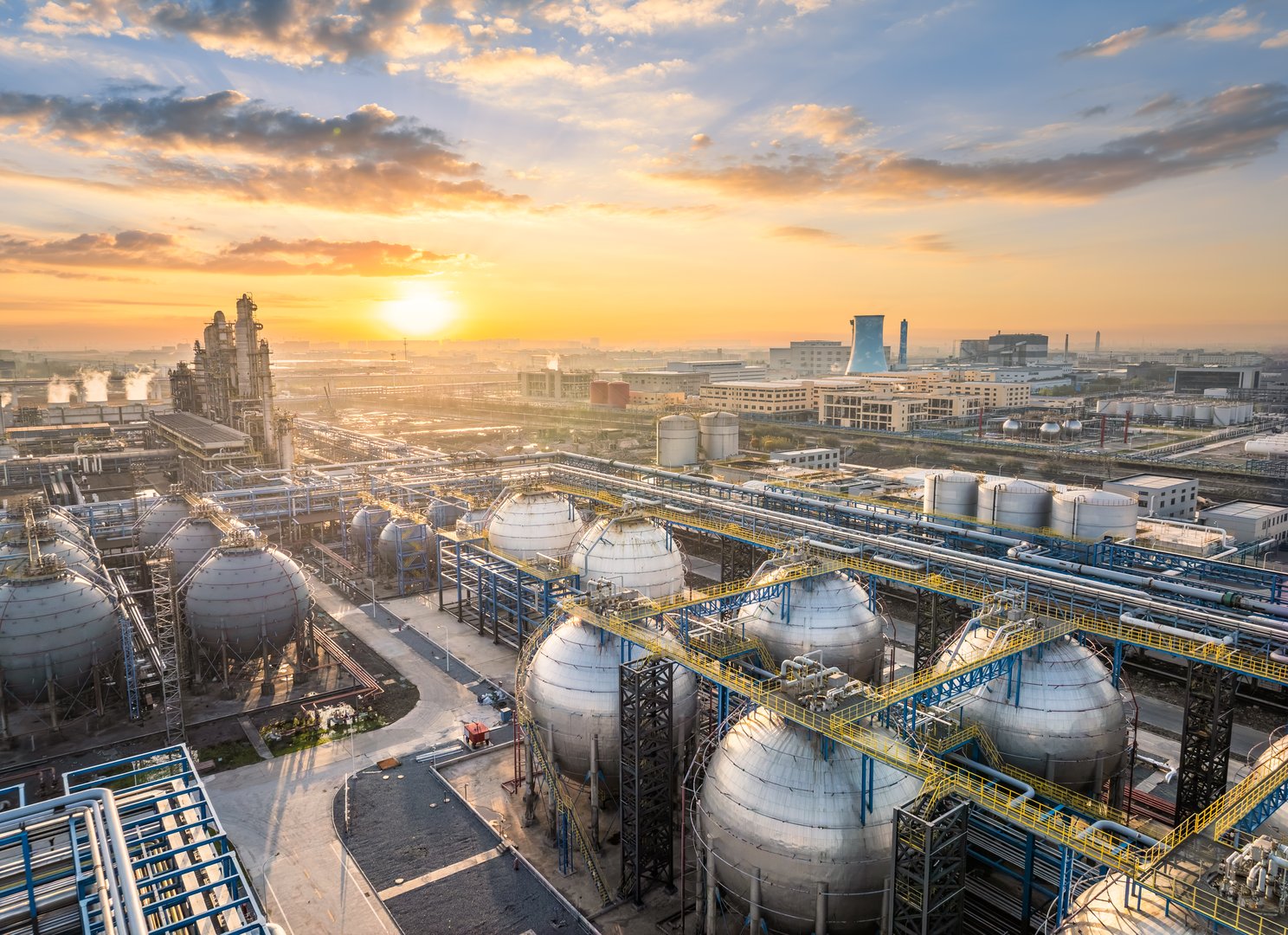 Aerial view of a refinery industrial plant with tanks and pipelines, emphasizing the scale of oil processing.