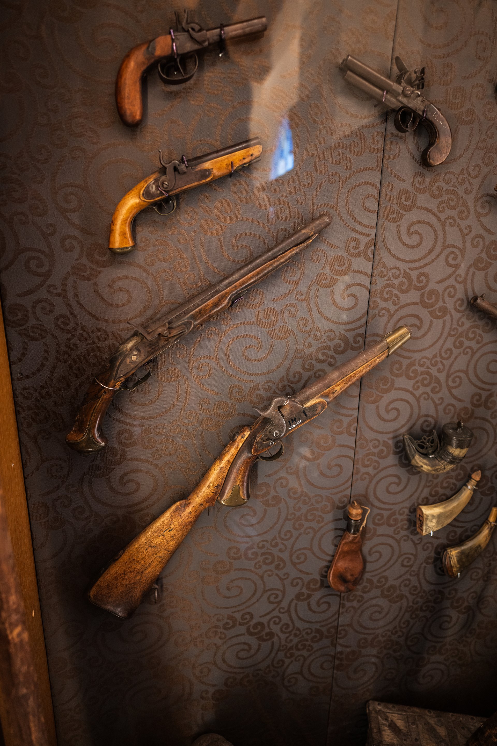 display of antique firearms in museum exhibit.