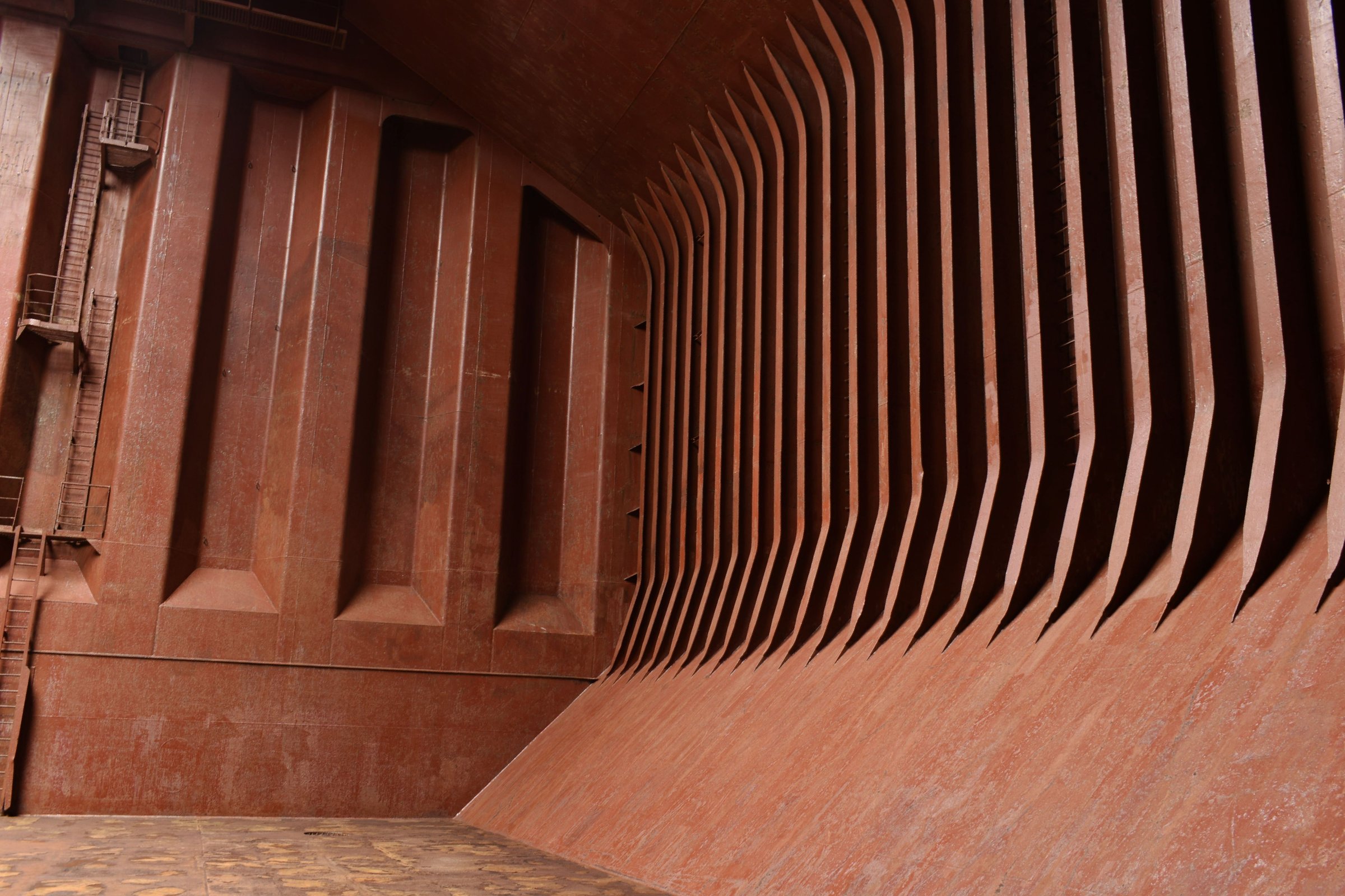 framework inside the large empty cargo hold of a bulk carrier ship