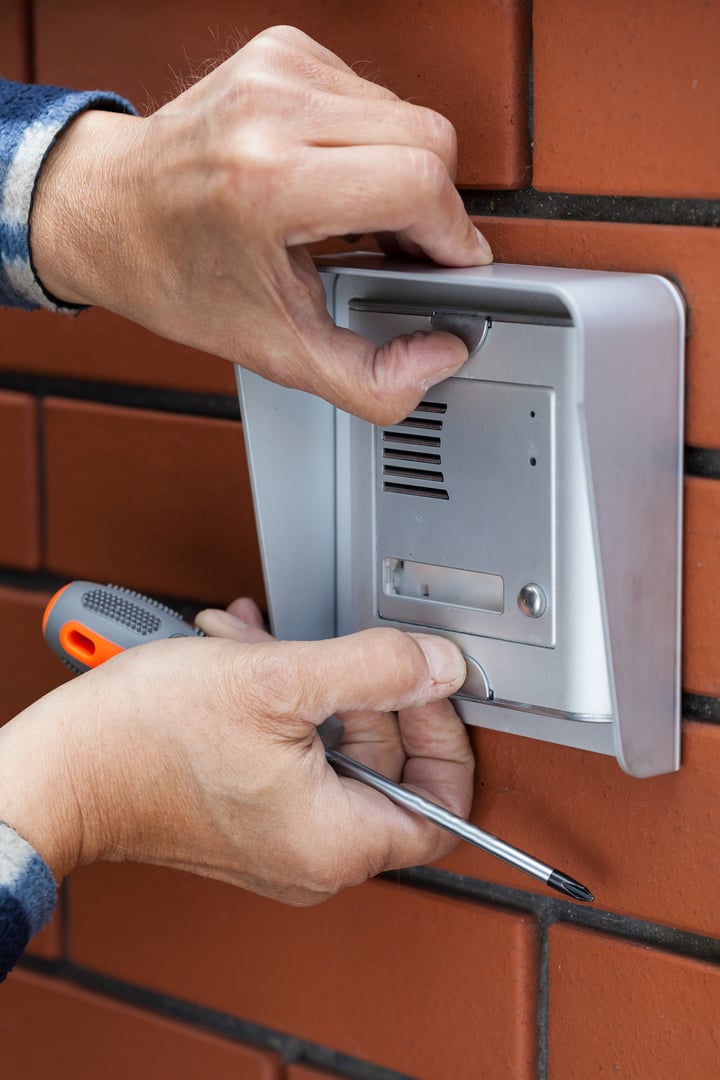 Close-up of a male hands repairing intercom, vertical