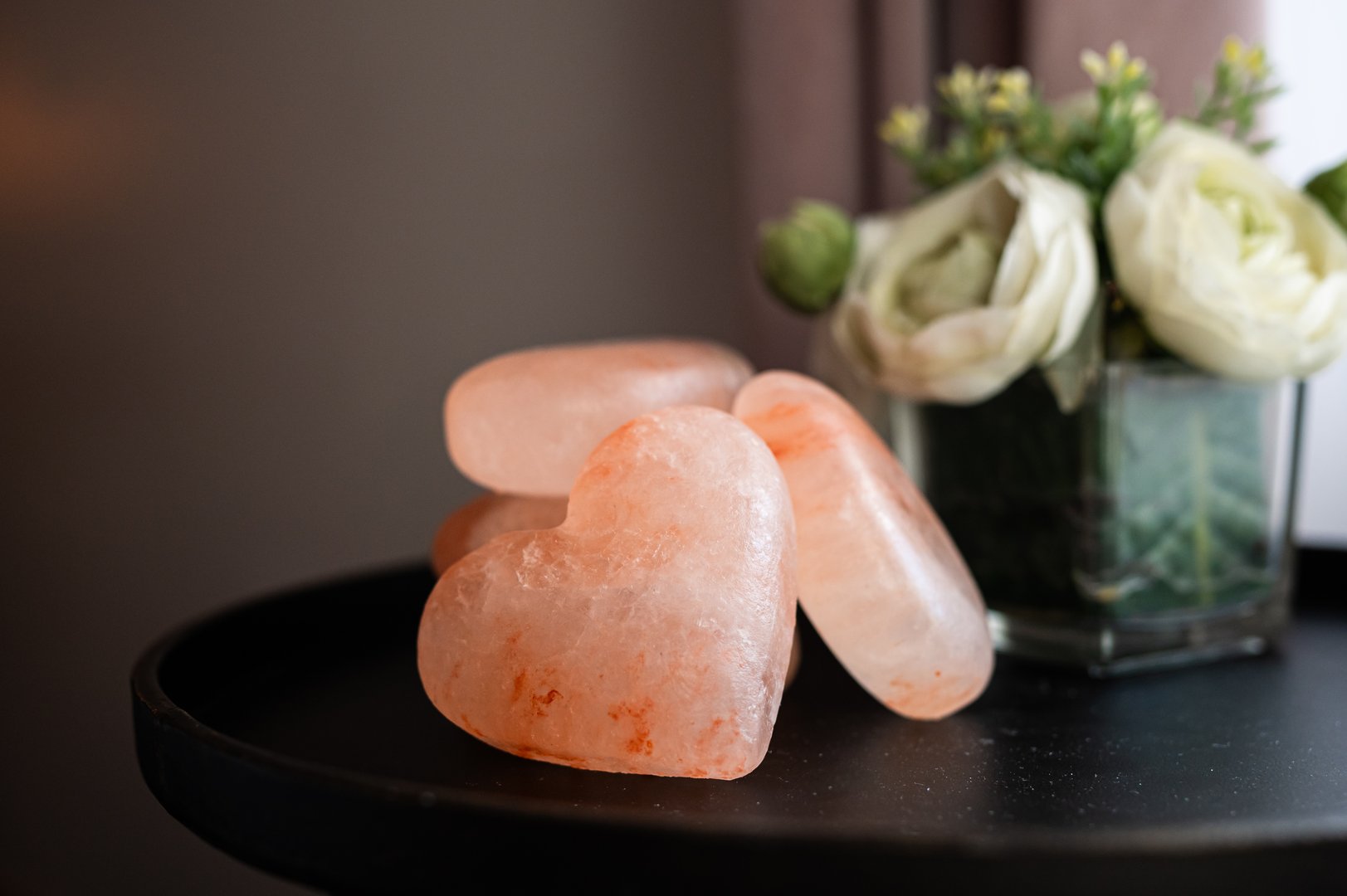 Himalayan salt heart stones placed on a table with decorative flowers. in Boston, Massachusetts, United States
