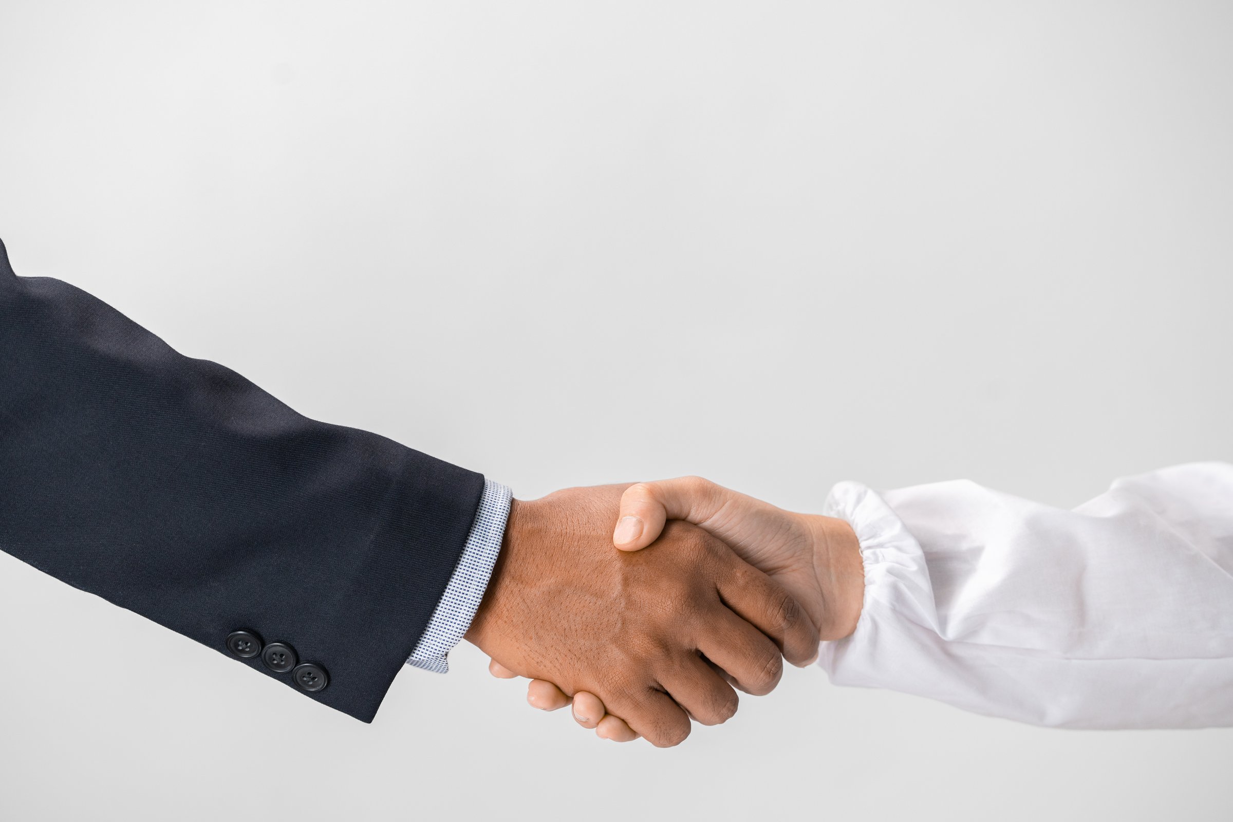 Closeup of a business handshake, isolated on white background.