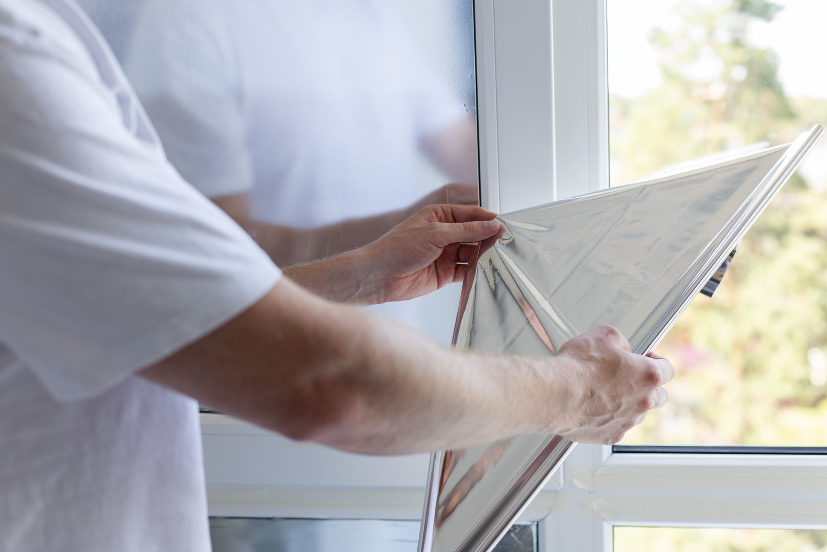 Man tinting windows at home with solar control film