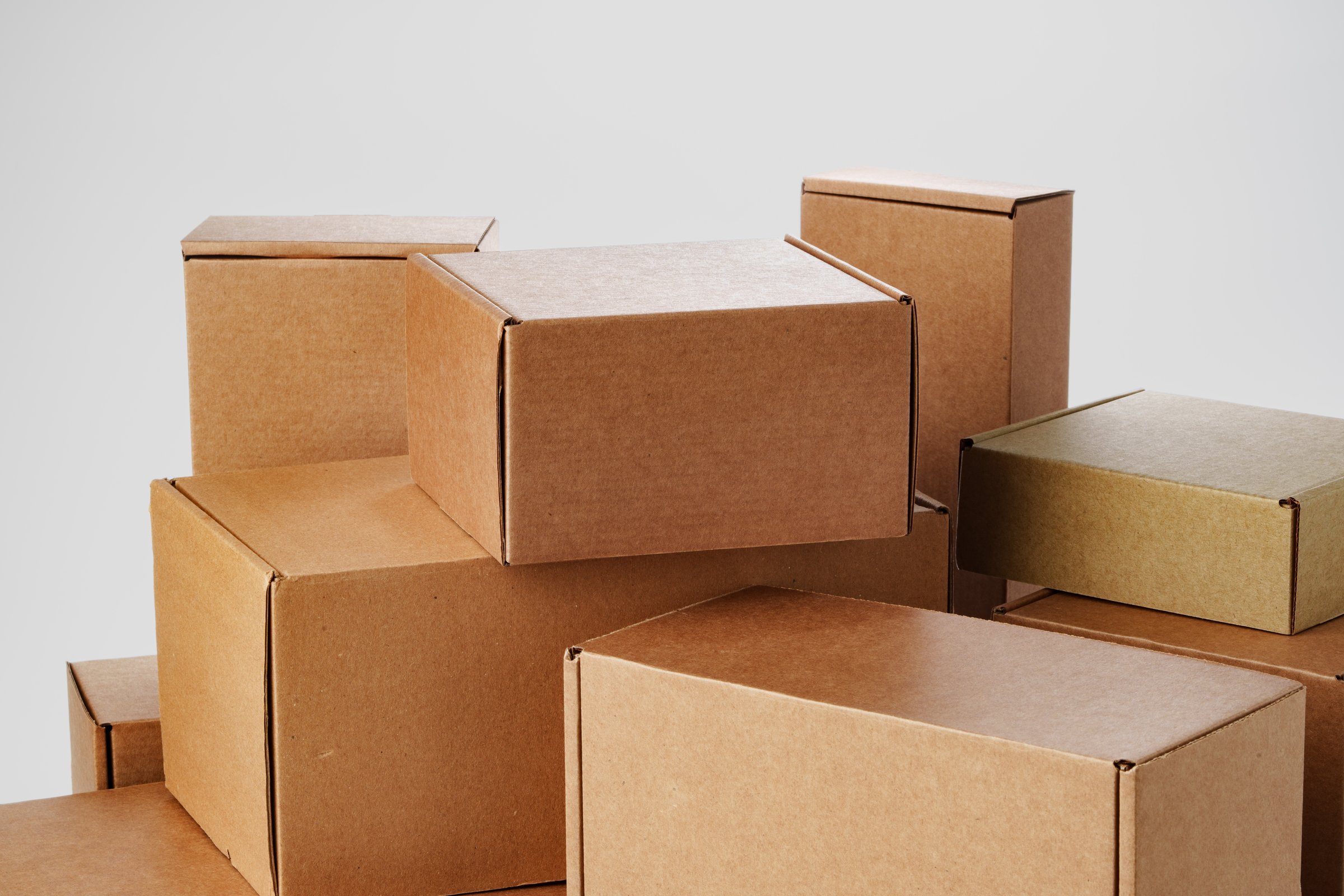 Stacked brown cardboard boxes in various sizes arranged on a white background for storage
