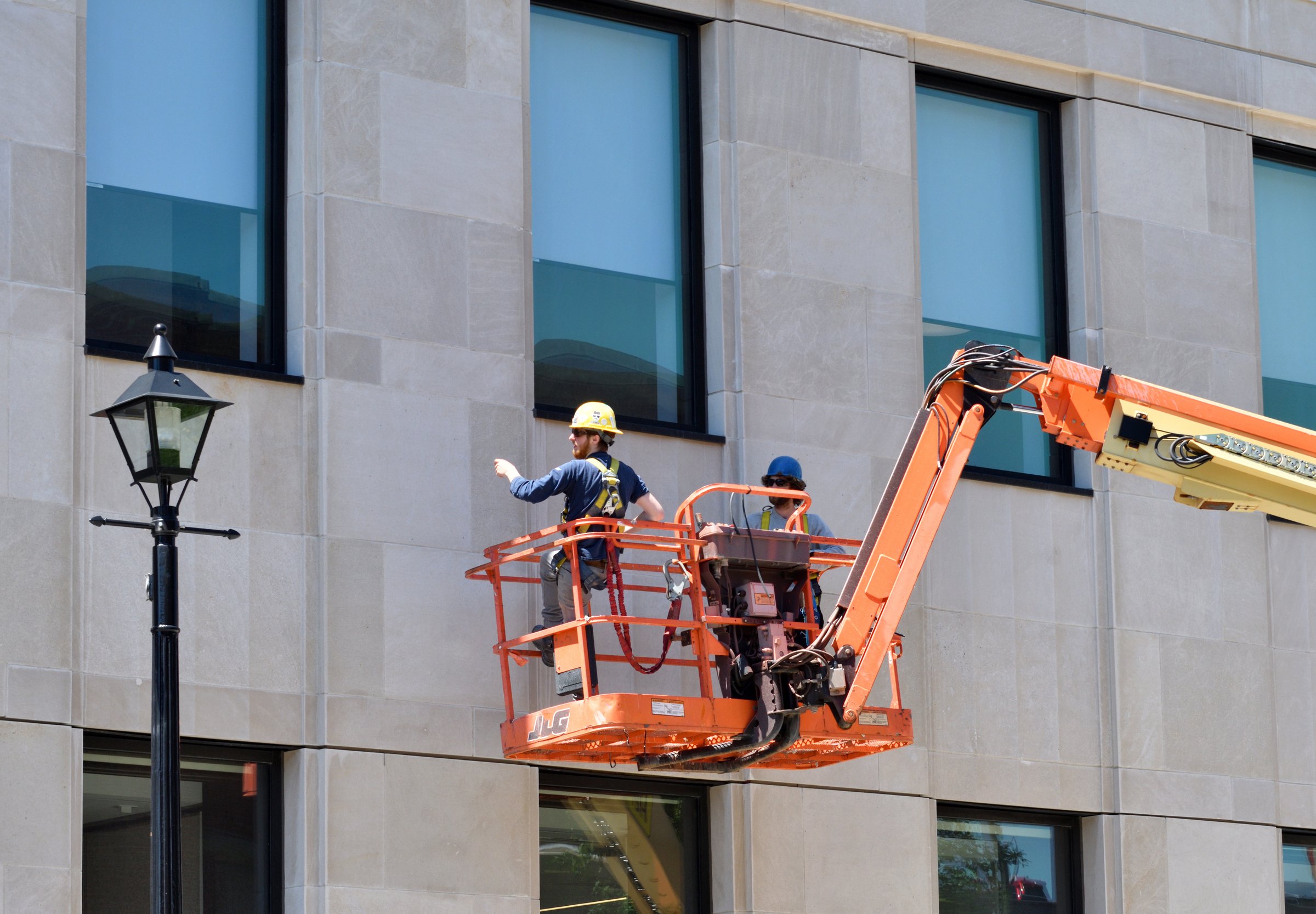 Saint John, New Brunswick / Canada - July 8 2019:  Two Men in a Lift Inspecting the Facade of a Building at a Construction Site