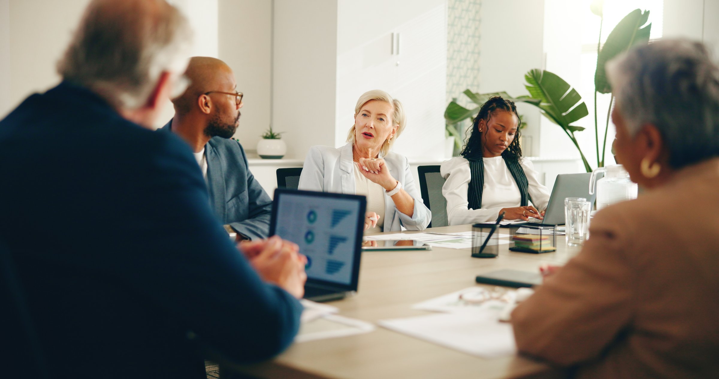 Business people, meeting and laptop in office for finance, company budget or explain expenses. Team, discussion and tech in boardroom for financial report, audit briefing or risk management at charts