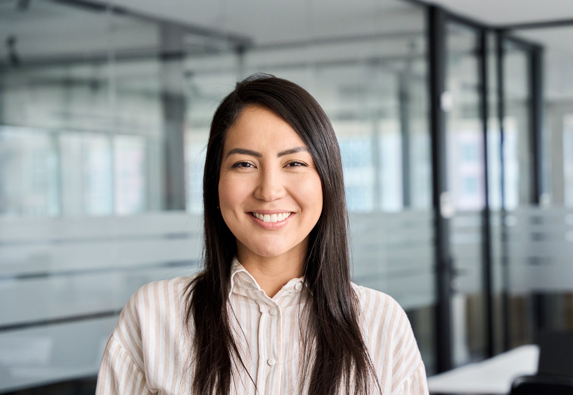 Confident smiling young professional Asian business woman corporate leader, happy japanese female employee, company sales marketing manager, standing in office, headshot portrait.