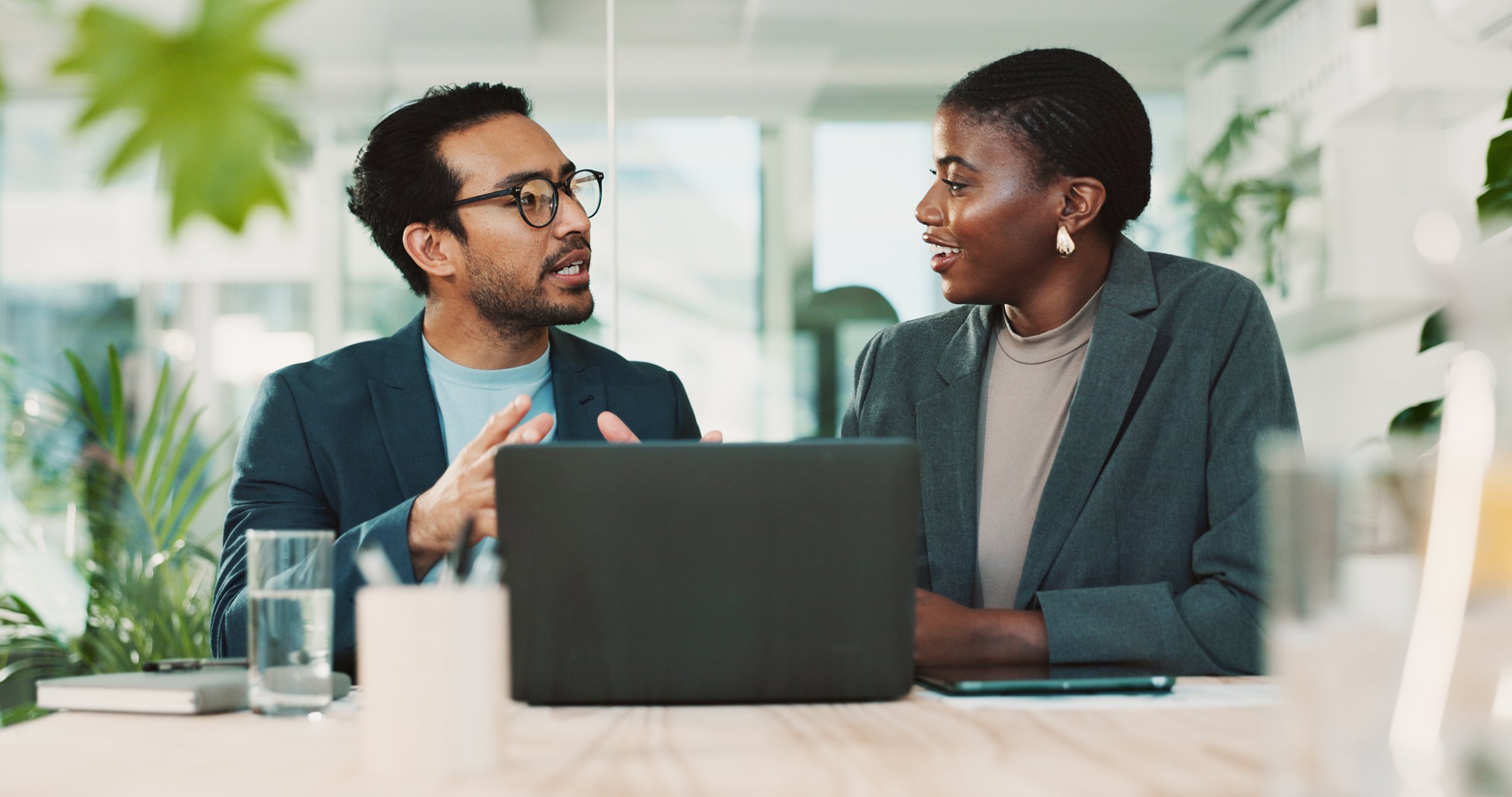 Office, partnership and team advice for laptop, proposal and research notes with document for report. Man, woman and feedback for small business, collaboration and meeting for training or b2b project