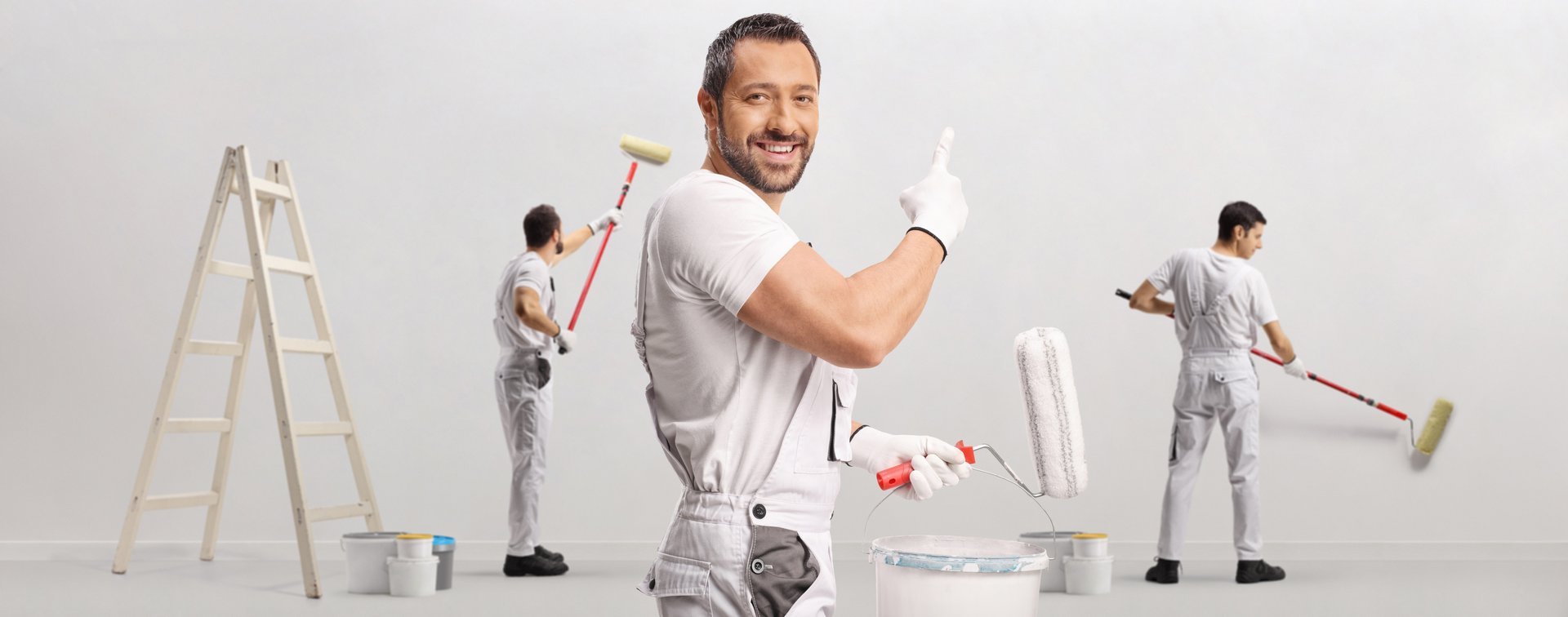 Workers doing masonry works and painting a wall