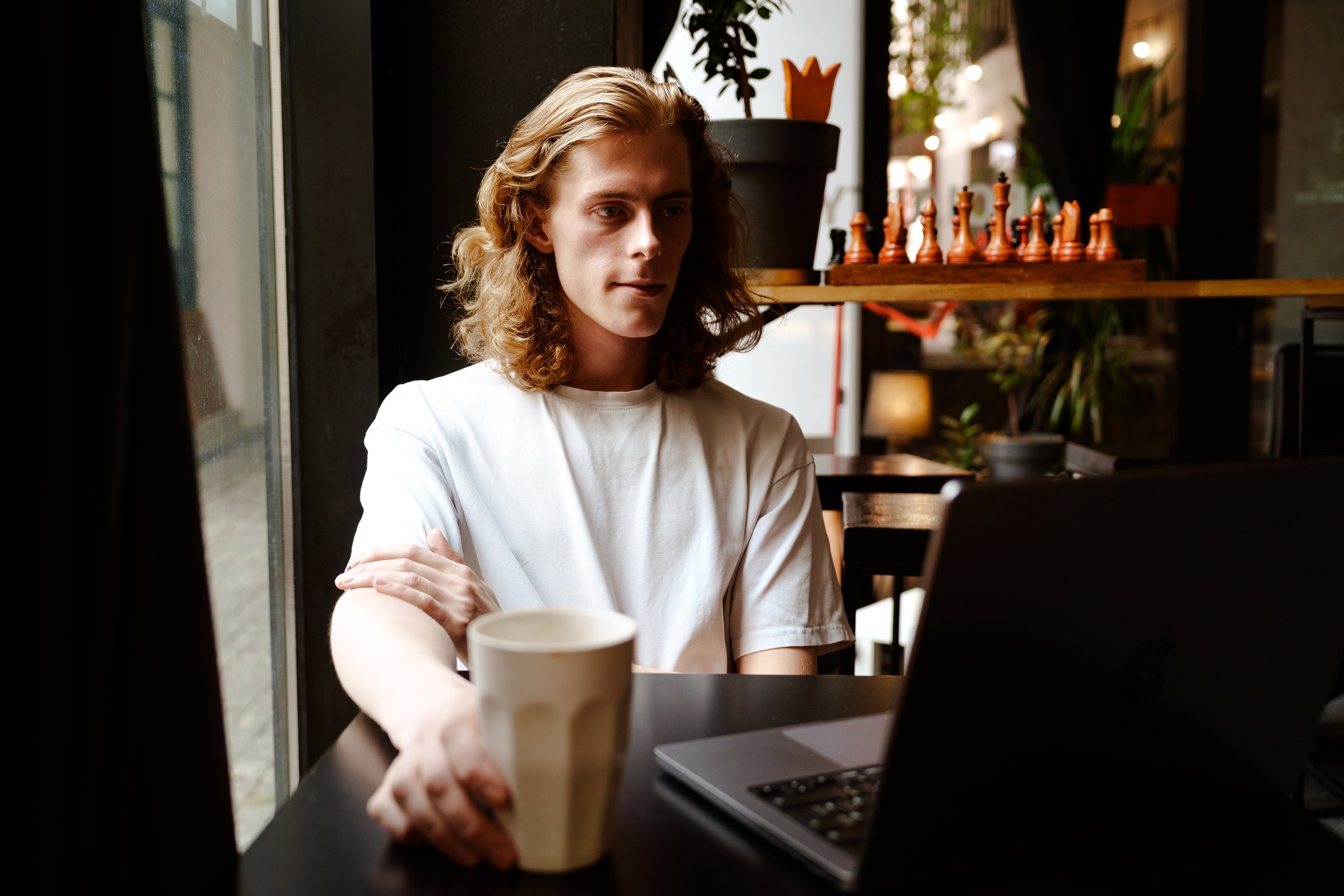 Young man working on laptop in cafe