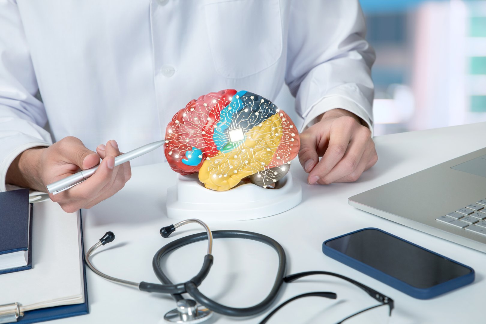 A medical professional examines a model of a brain featuring connected technology. The setting includes various tools and devices used in neuroscience and research.