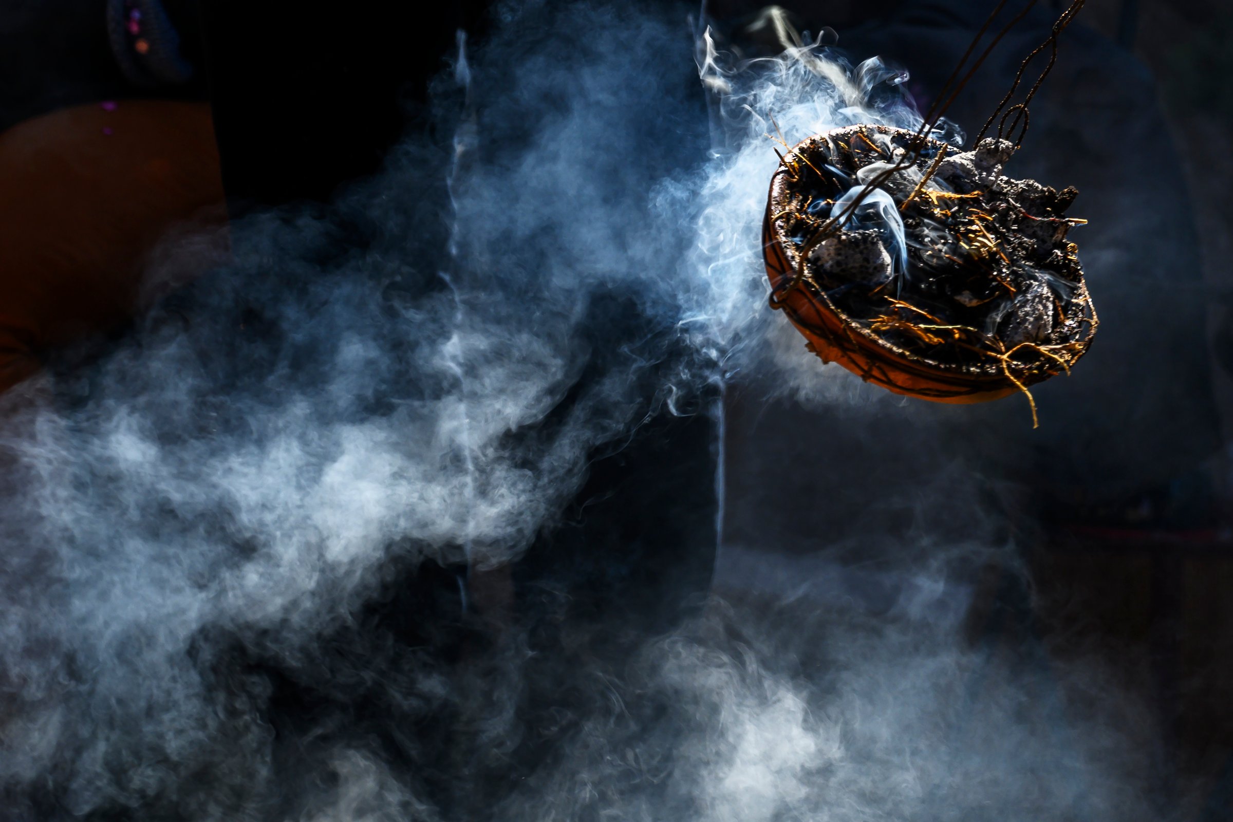 Andean ceramic incense burner releasing smoke at a Pachamama celebration