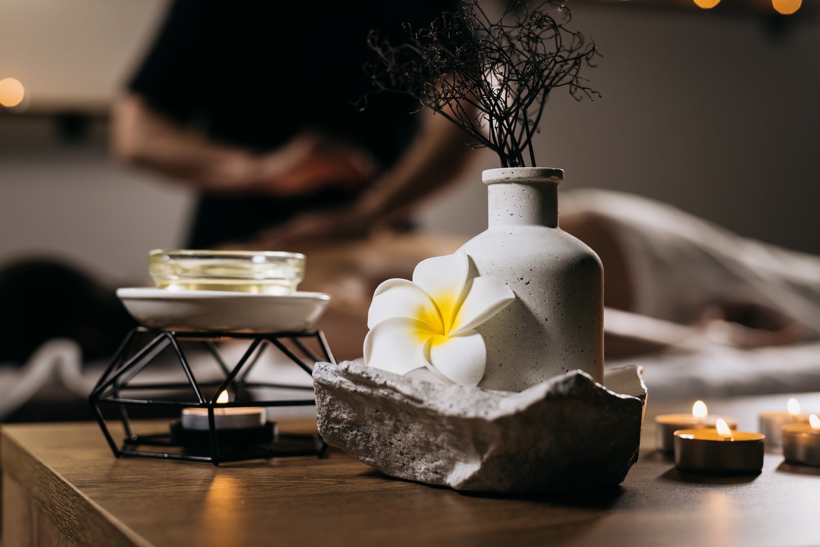 A relaxed woman enjoys a soothing massage in the tranquil setting of a spa that epitomizes serenity and well-being.