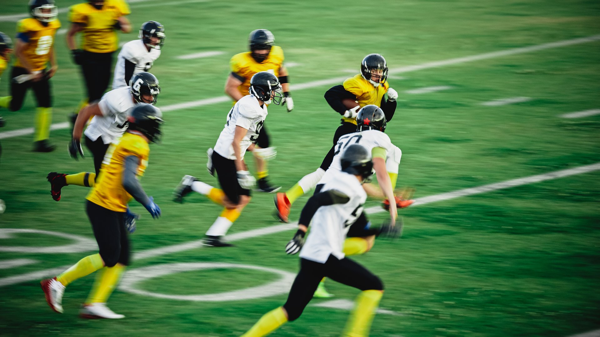 American Football Teams Start Game: Professional Players, Aggressive Face-off, Tackle, Pass, Fight for Ball and Score. Warrior Competition Full of Brutal Energy, Power, Skill.