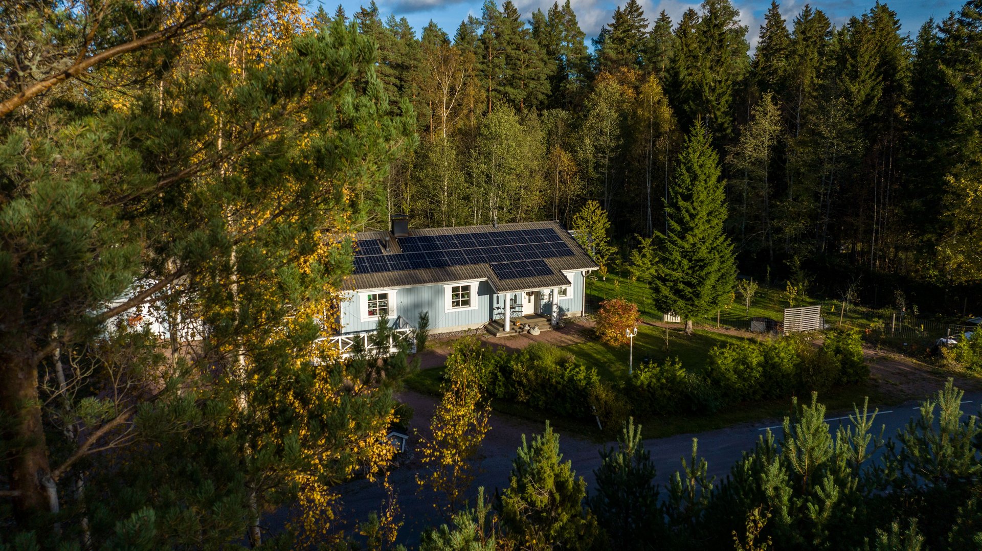 Aerial view of a detached home powered by photovoltaic cells, on a sunny autumn day