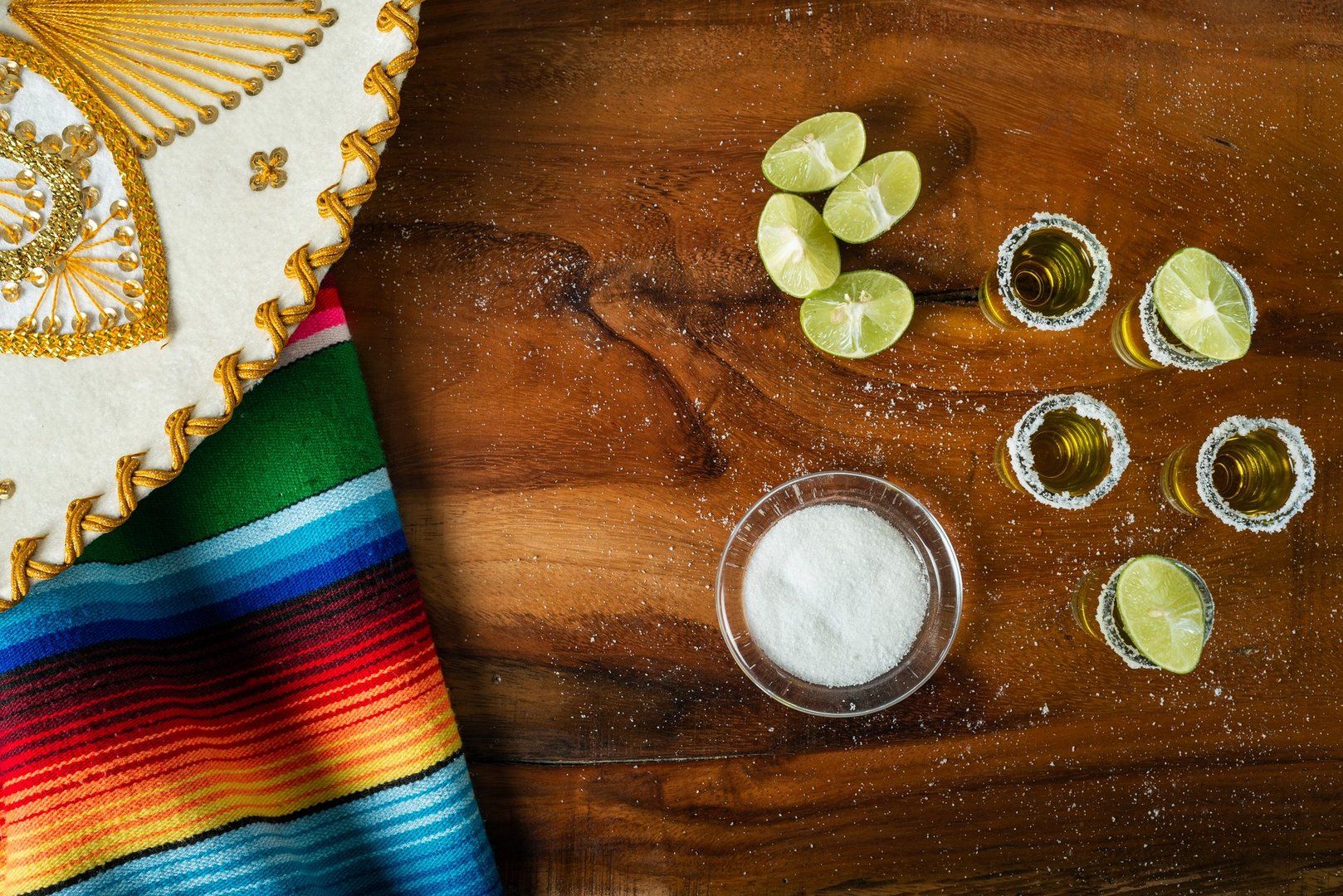 Shots of tequila with salt and lemon on a wooden table. Festive background cinco de mayo and mexican independence day.