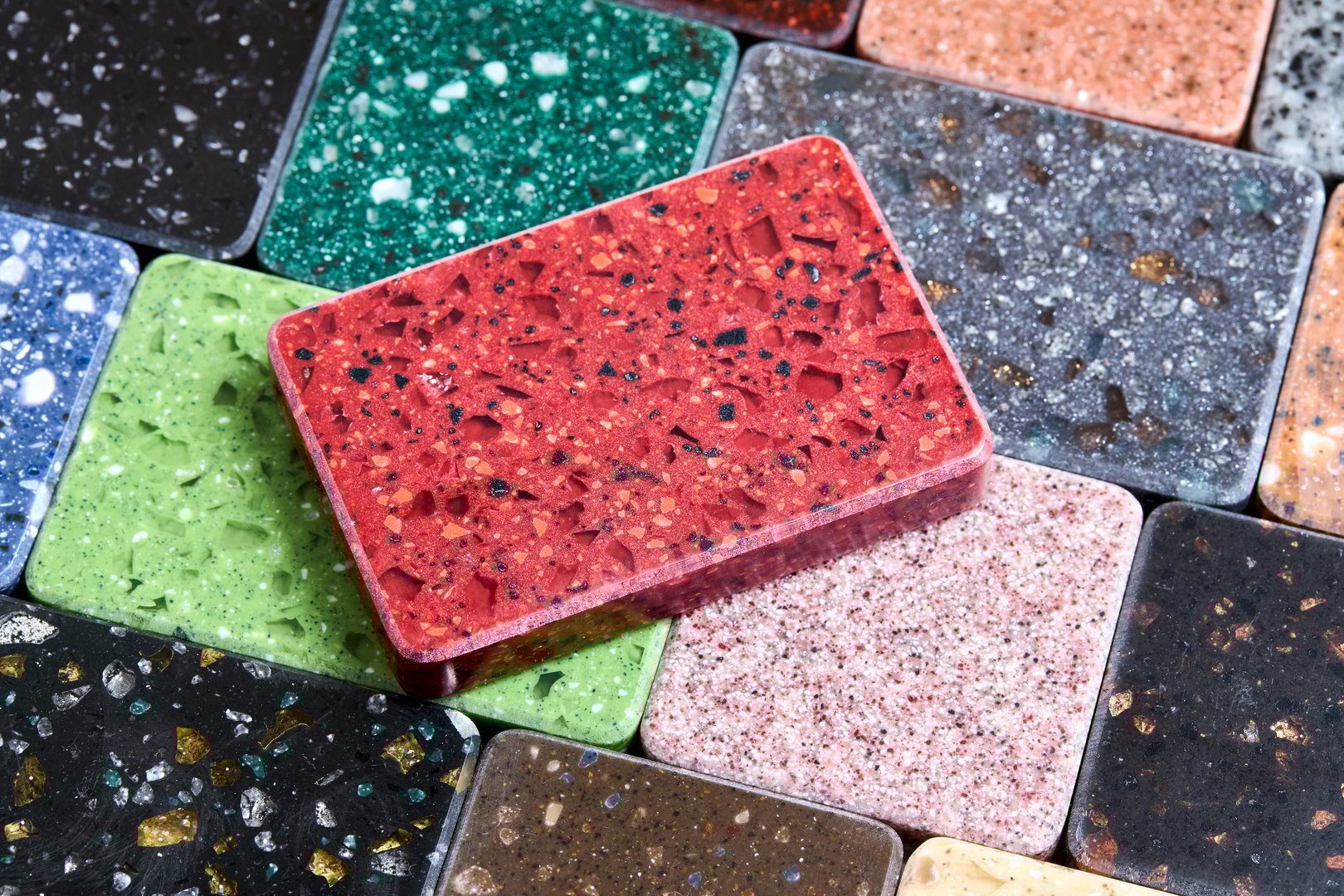 Porcelain stoneware artificial stone square samples as kitchen countertop examples of future kitchen fasade exterior. Samples slabs of natural granite marble quartz for stone countertops close up.