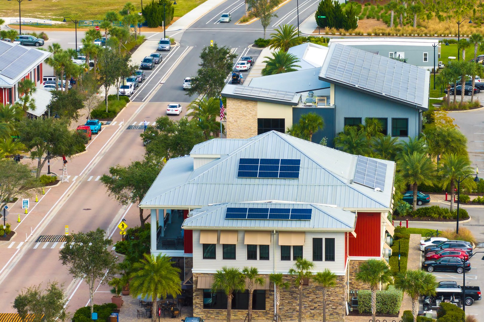 Solar rooftops in commercial center in Florida sustainable town. Photovoltaic panels for producing of clean ecological electrical energy in city area. Concept of autonomous building.