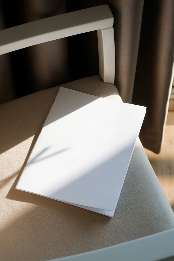 magazine cover mockup design. blank magazine template on soft beige armchair in living room or hotel room, shadow overlay