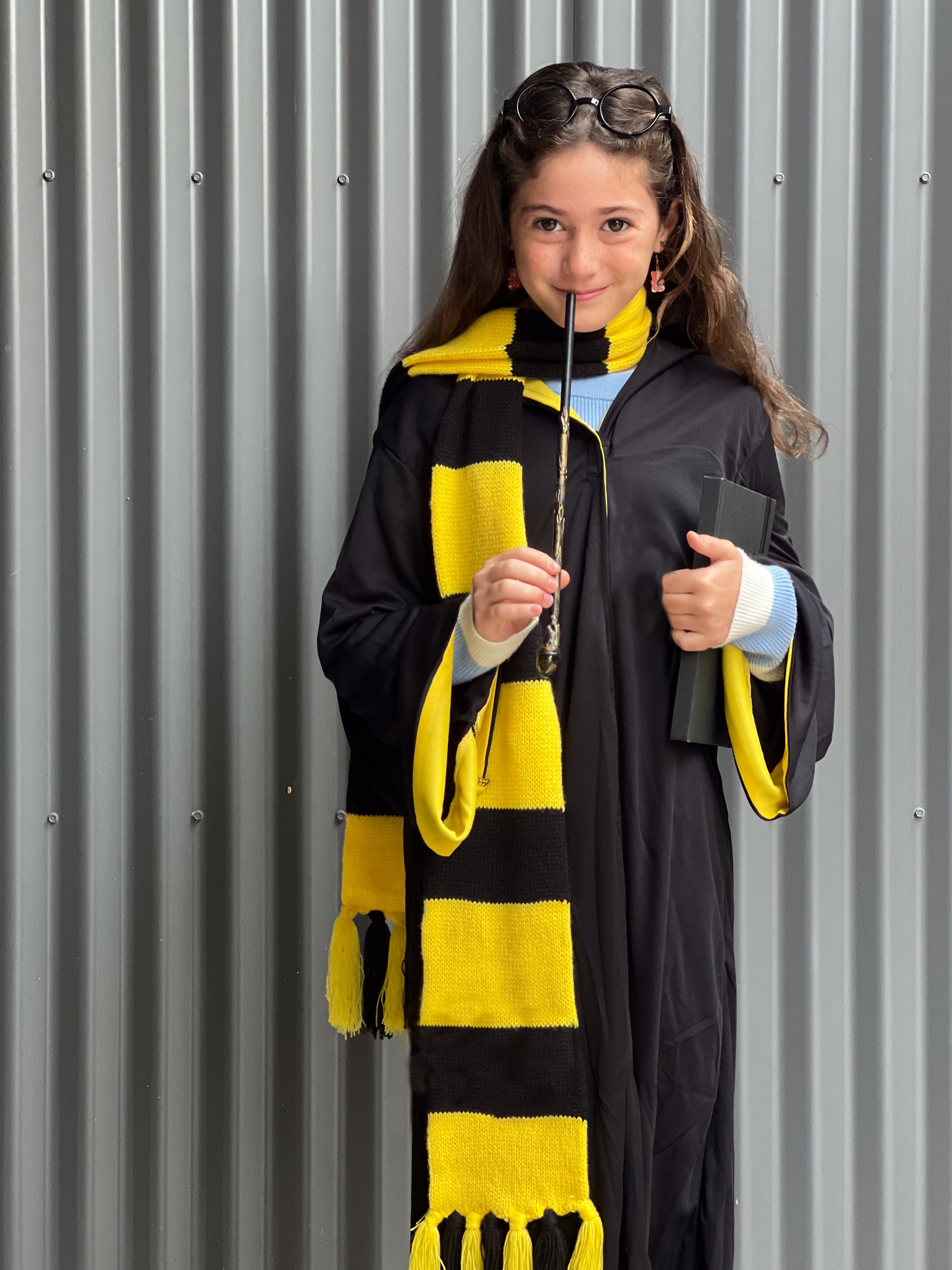 Young Jewish girl (female age 10) wearing a costume of young wizard scholar looking at camera on Purim Jewish holiday.
