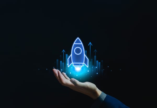Hand holding glowing rocket icon with rising graph arrows, symbolizing startup growth, business innovation, technology development, future success, and financial investment opportunities
