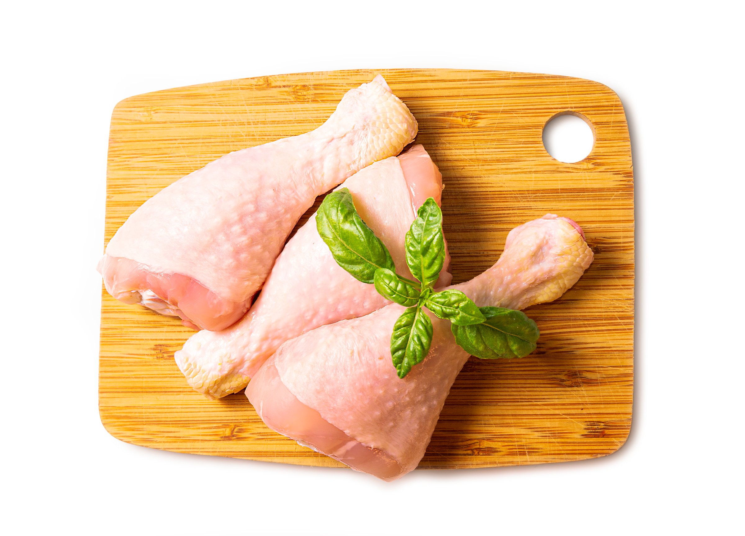 Raw chicken drumsticks on white background