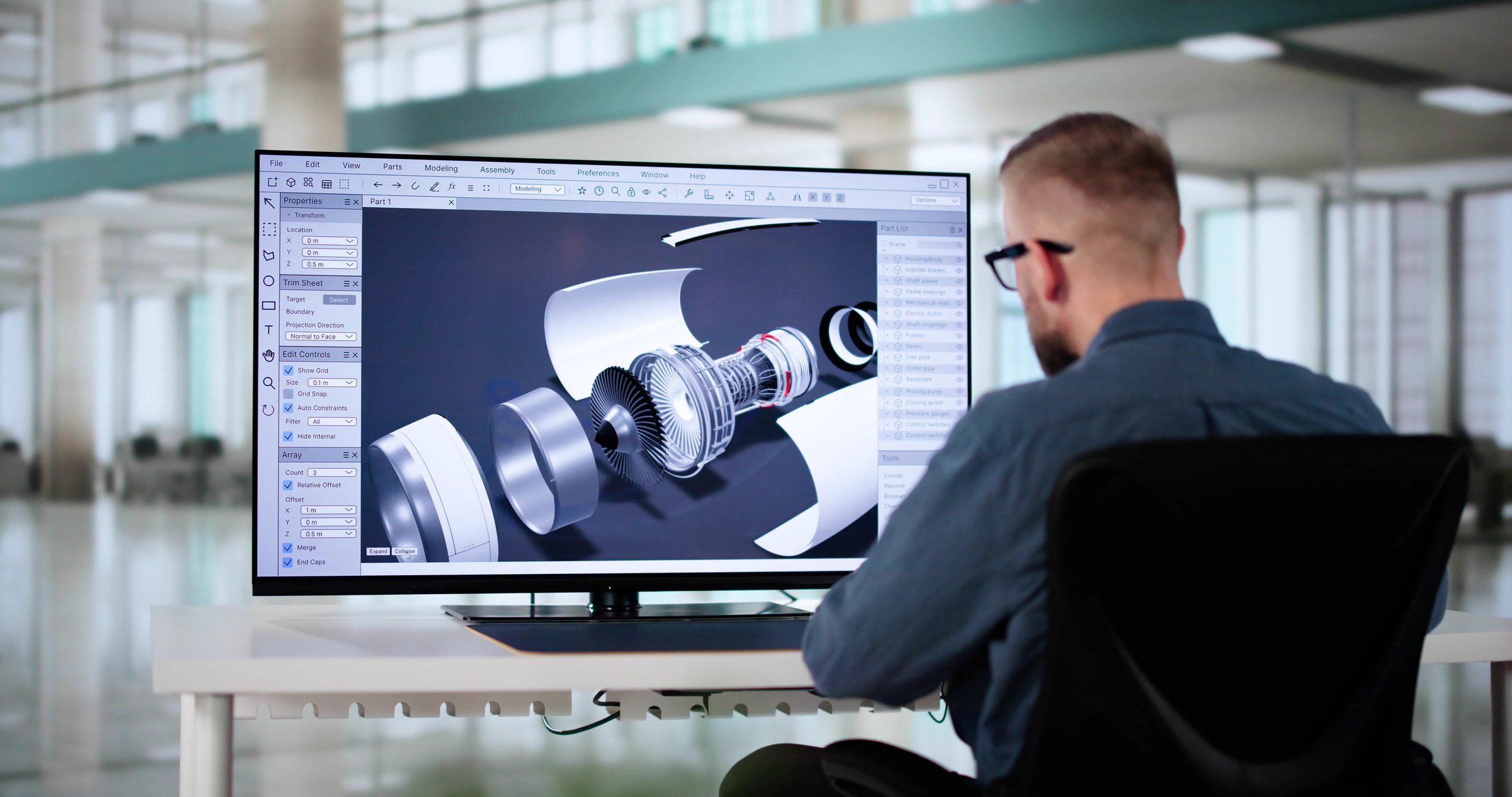 Male Engineer Developing Mechanical Parts Using 3D CAD Software On Laptop At Factory Office