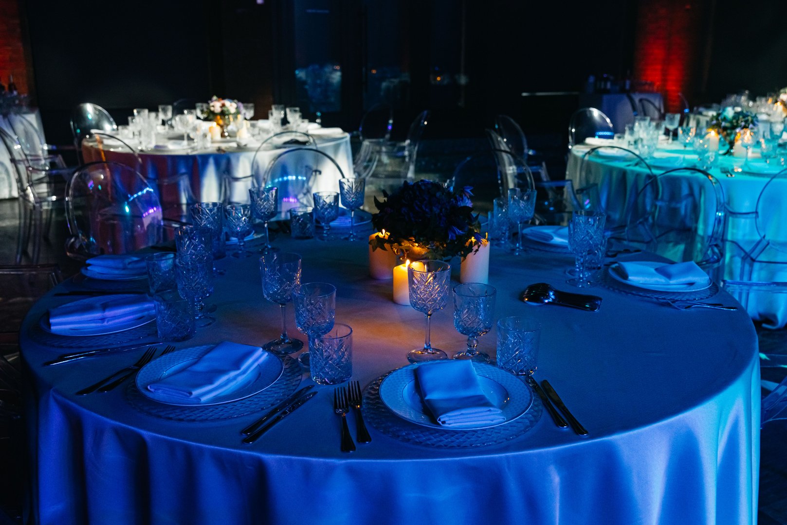 Luxurious banquet setup with crystal glassware, floral centerpieces, and candlelight creating a romantic and upscale evening ambiance.