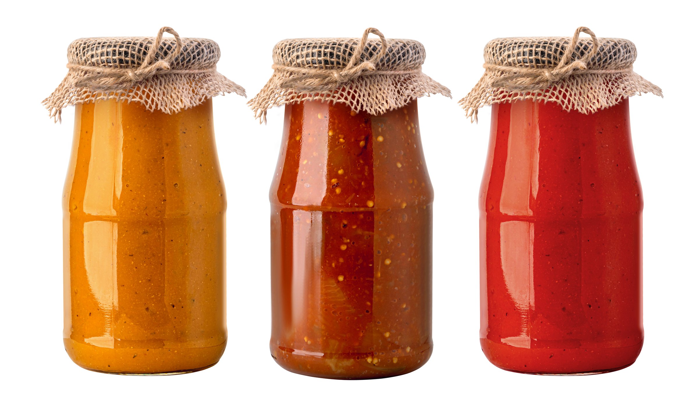 Three glass jars of preserved homemade sauces, featuring variety of colors, on transparent background