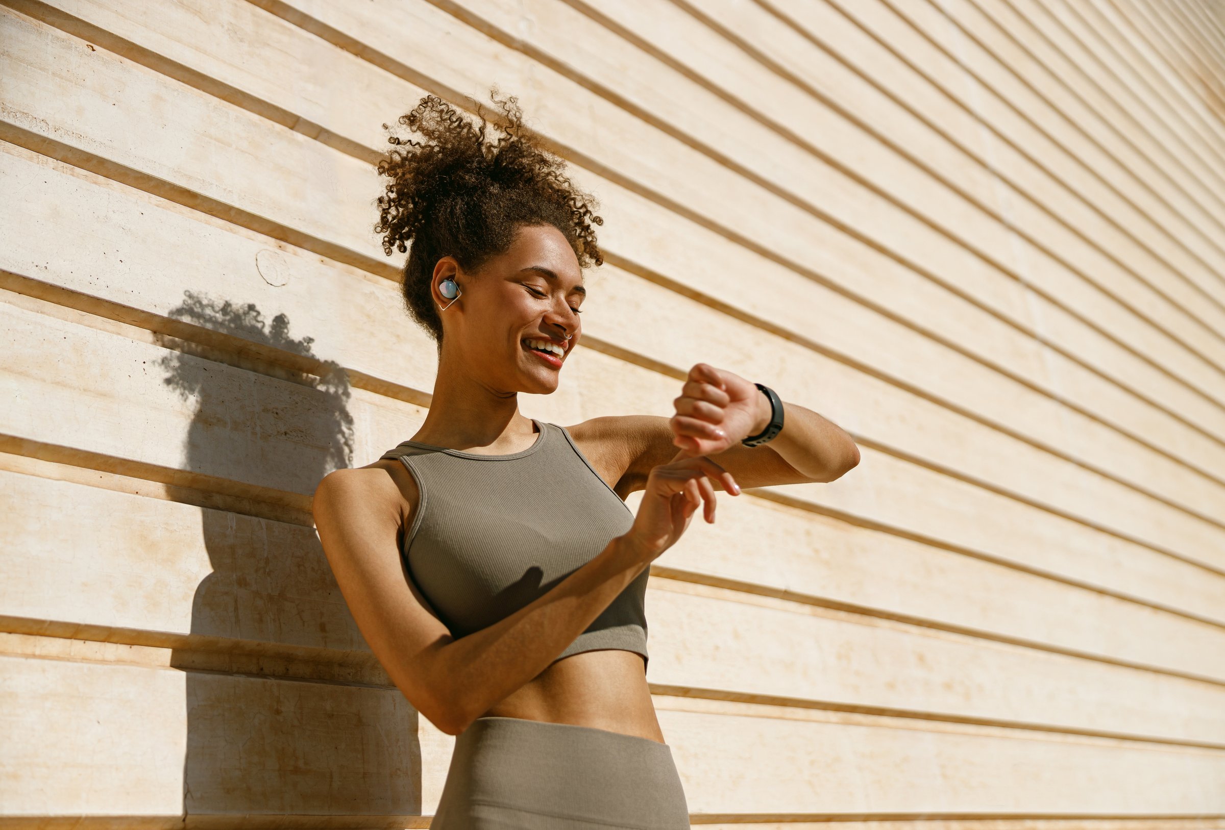 Young fit woman looking at smartwatch and counting calories burned. Healthy life concept