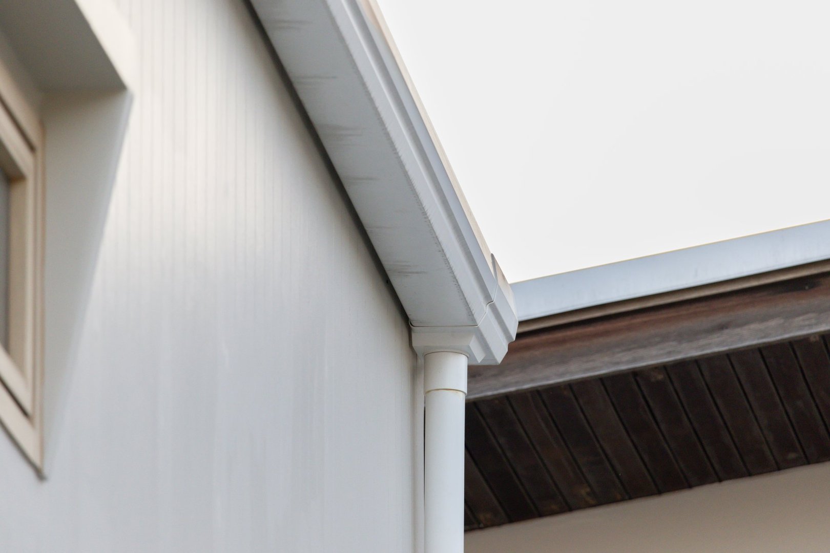 A white house with a white roof and a white gutter. The house has a clean and simple appearance, with the white color giving it a classic and timeless look