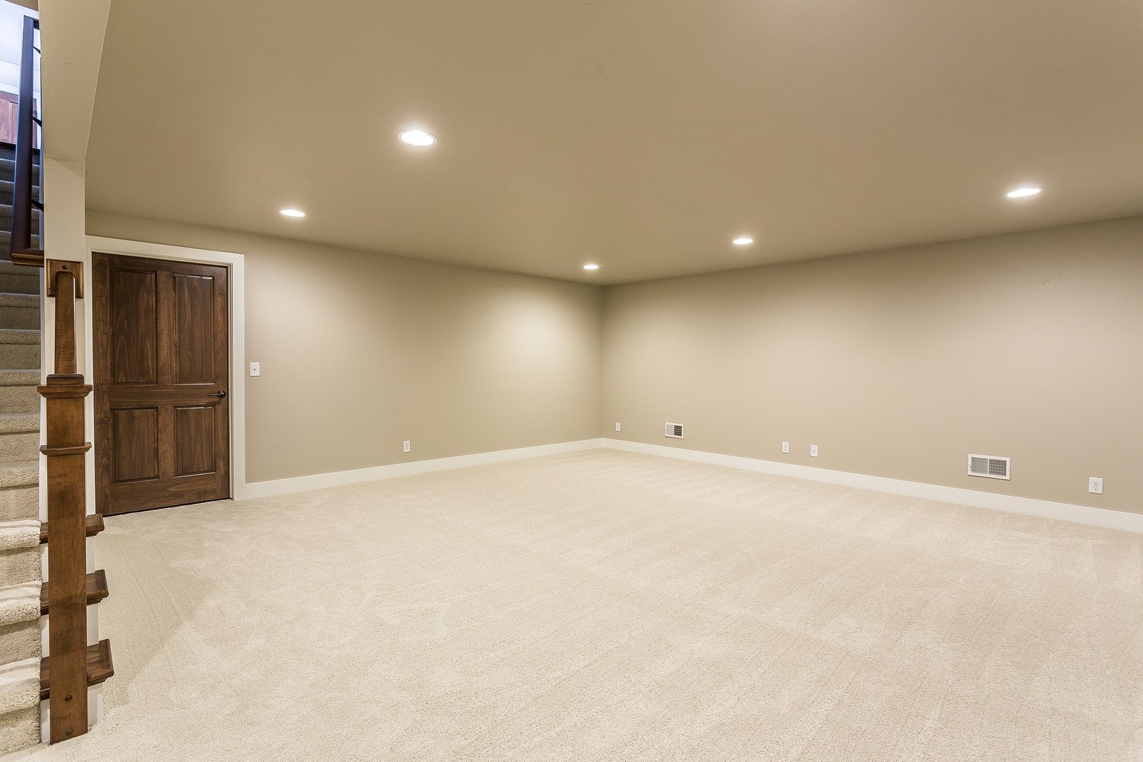 Light colored carpet with plenty of LED wafer lights to make this basement bright