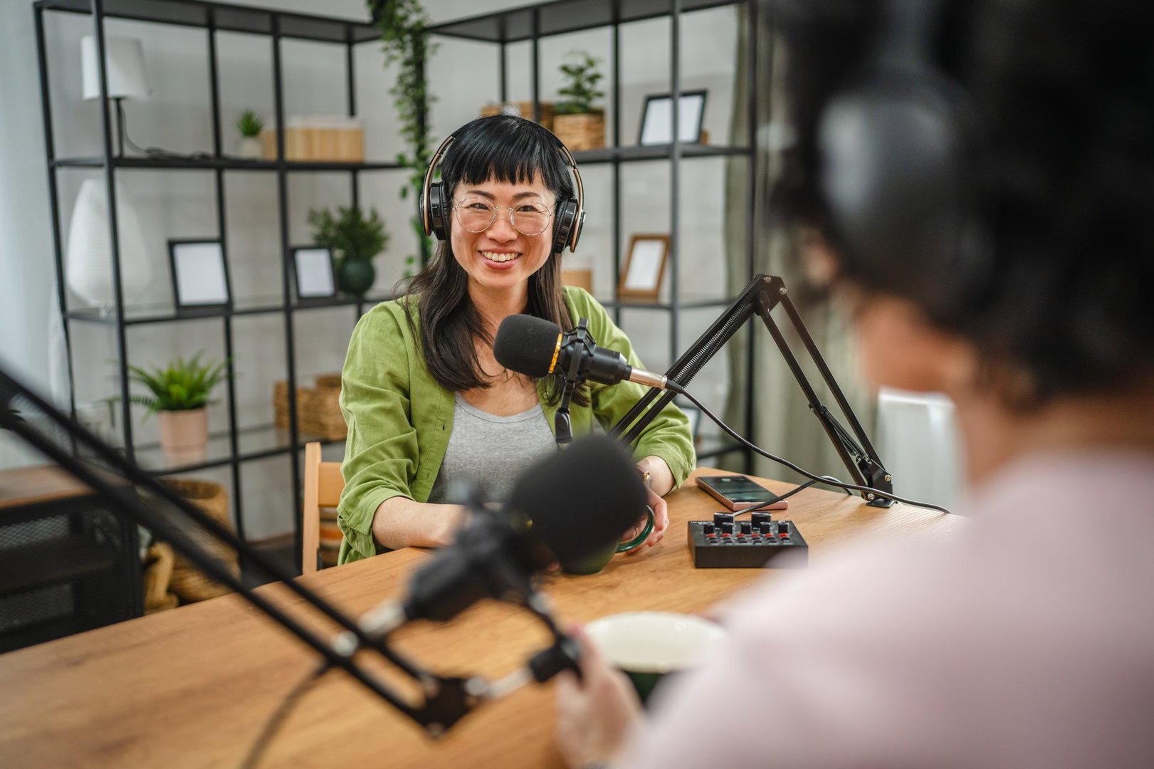 woman in the podcast studio talk and record, focus on a japanese woman talk into a mic