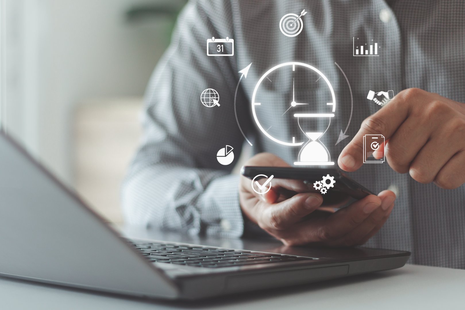 Time management project planning business internet technology concept. Businessman using smartphone with Hourglass clock on laptop computer concept for time management.