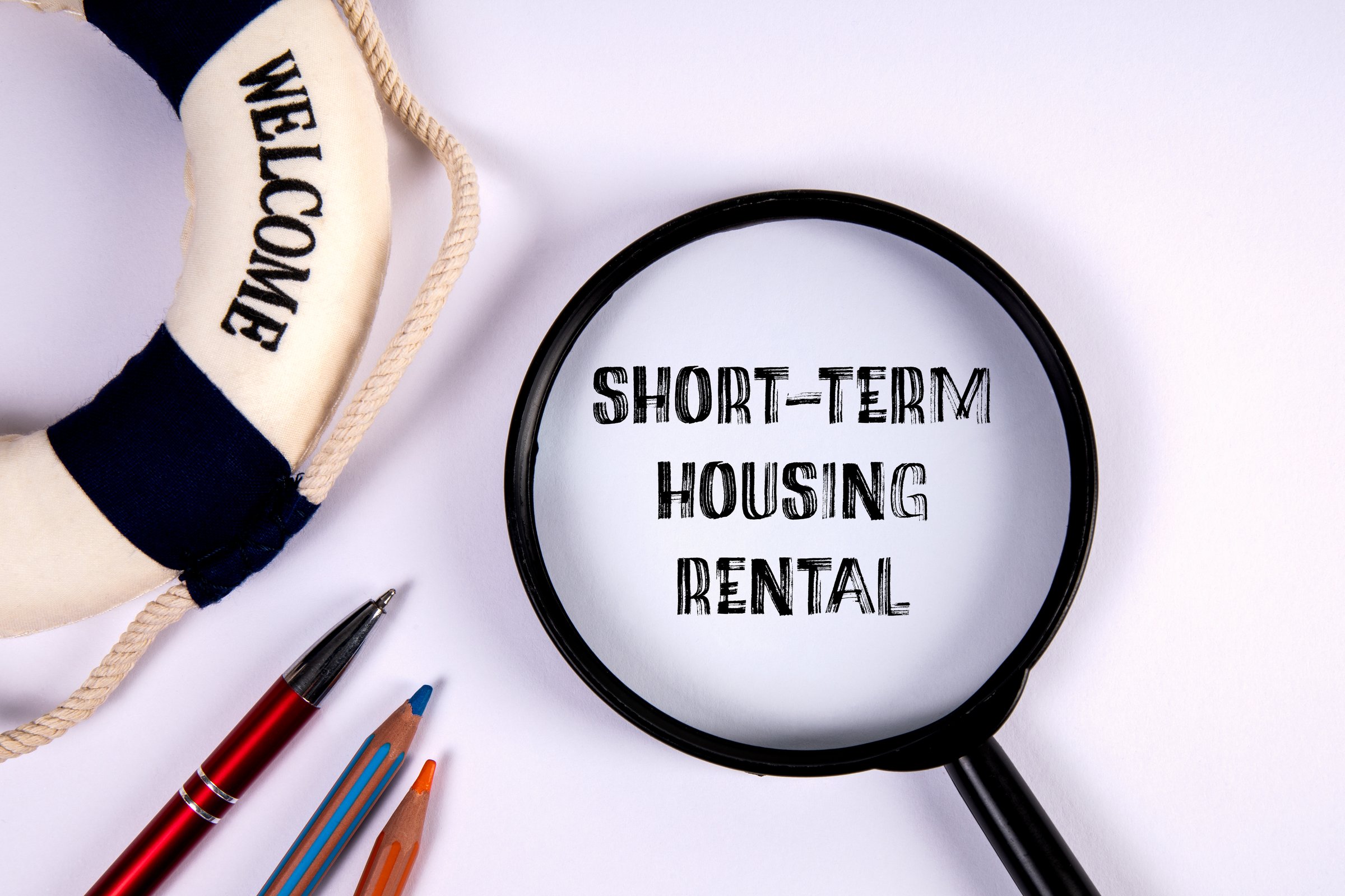 Short-Term Housing Rental. Magnifying glass with text on a white background.