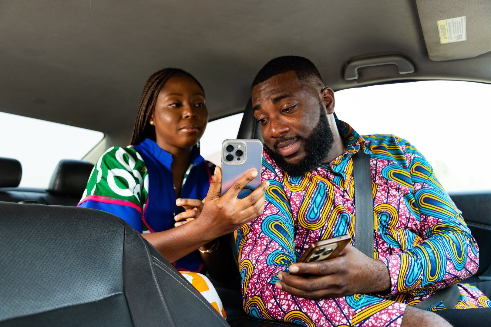 African female passenger making digital payment in car