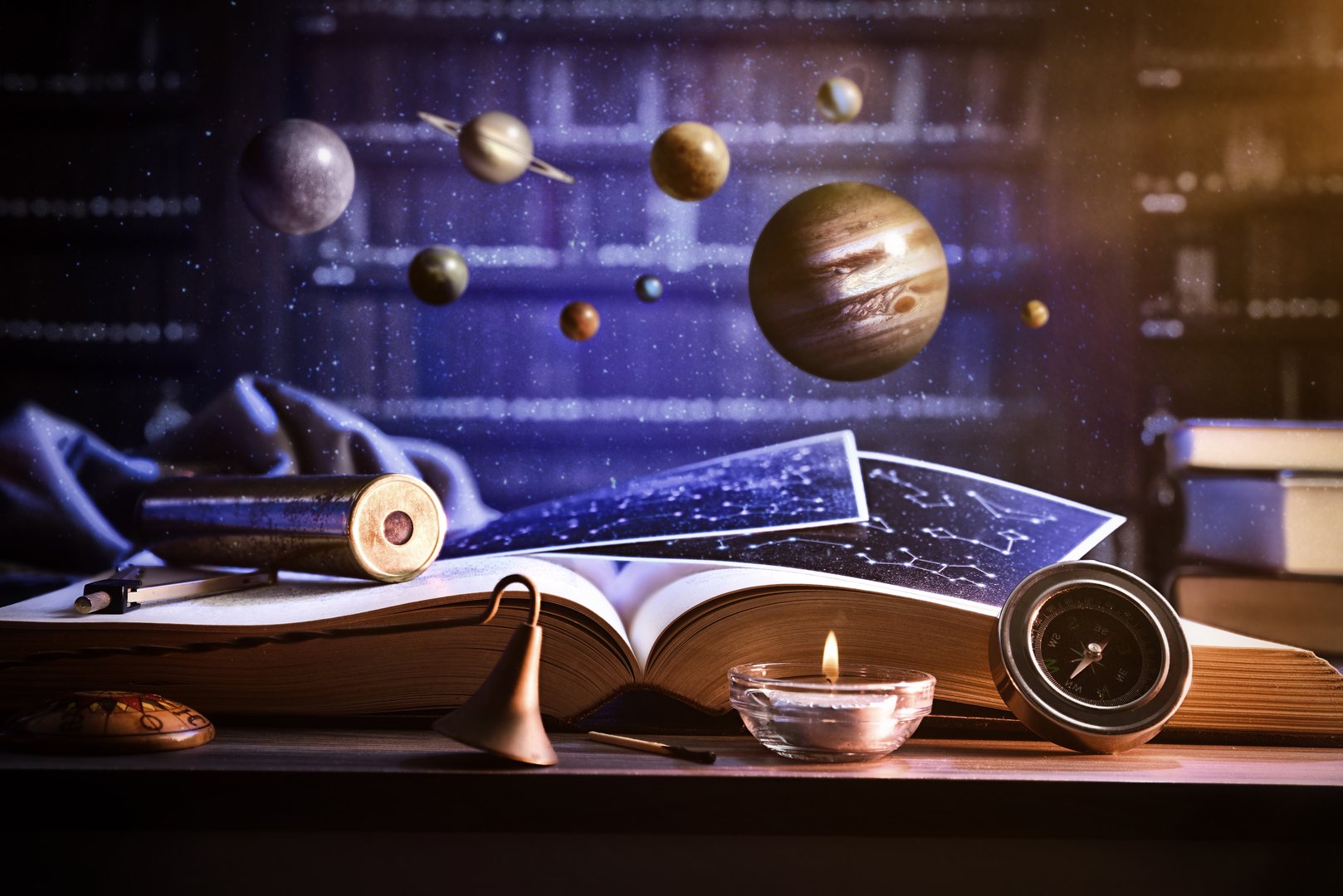 Concept of knowledge and awareness of stars and universe with a table with an open book and decorative objects for exploration with suspended planets and library with books. Front view.