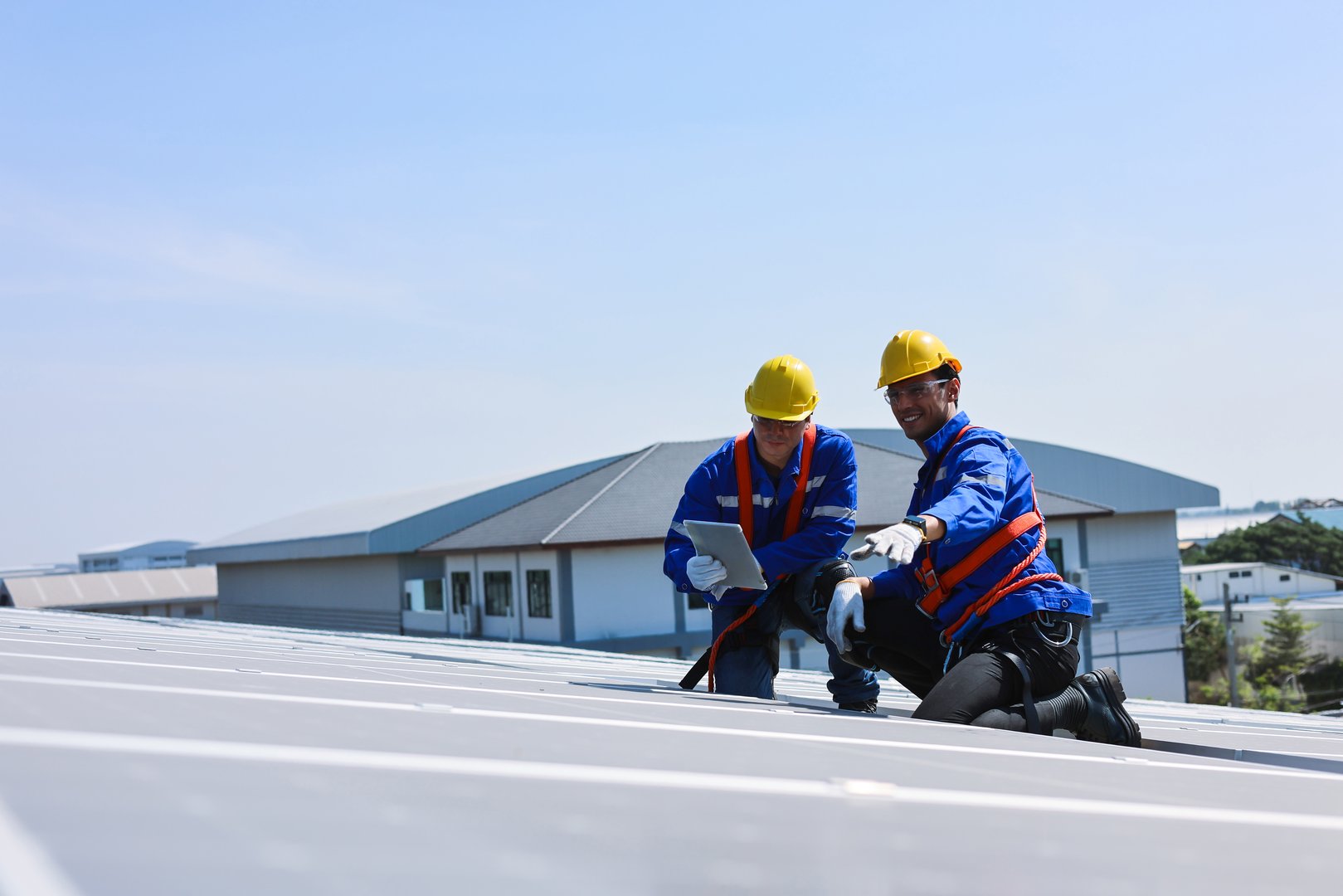Two caucasian engineers are talking to solve solar panel malfunction.