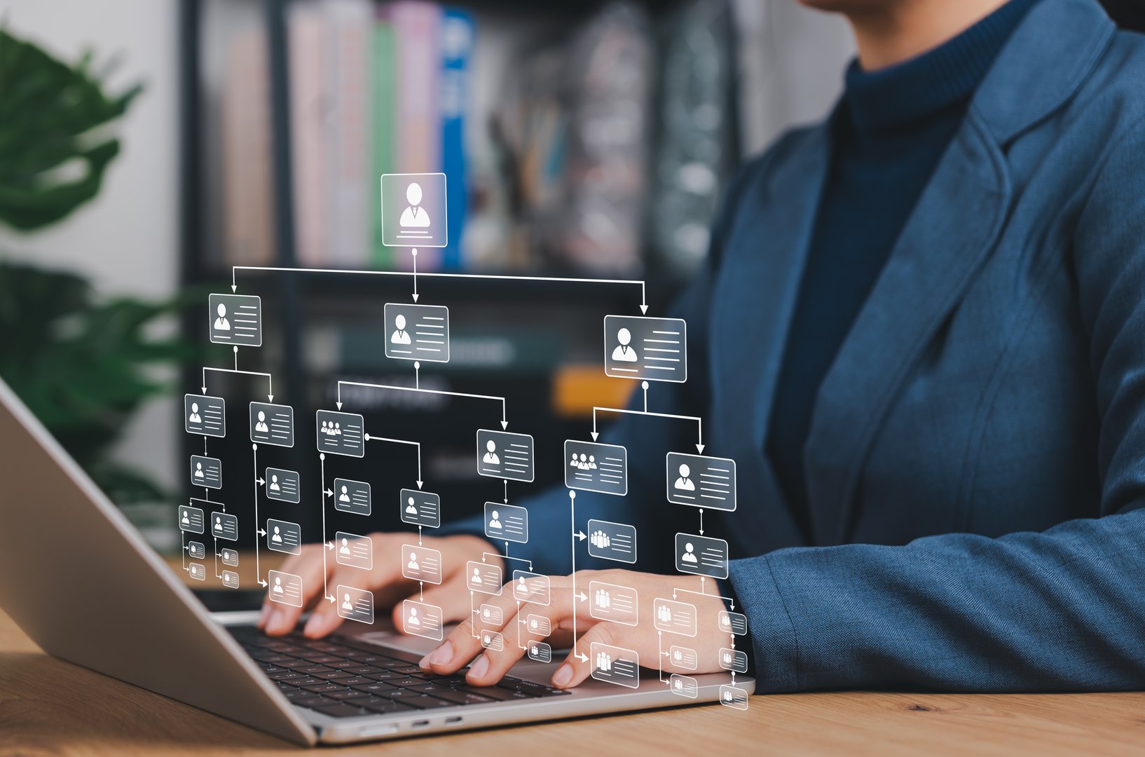 Businesswoman working on a digital organizational chart on a laptop, representing human resource management, company hierarchy, workforce planning, and team structure in a corporate environment.