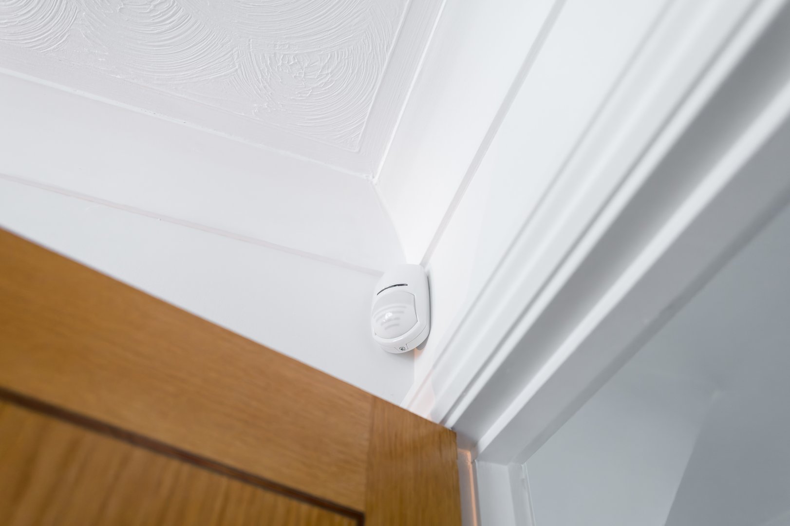 Newly installed wireless and battery operated new generation PIR alarm sensor in a downstairs room. Connected to a central alarm system which is activated on body heat.