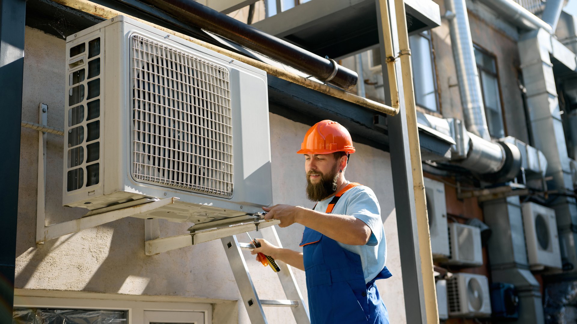 Technician installing air conditioning unit outdoors. Concept of engineering services, HVAC maintenance, and workplace safety with focus and confidence.