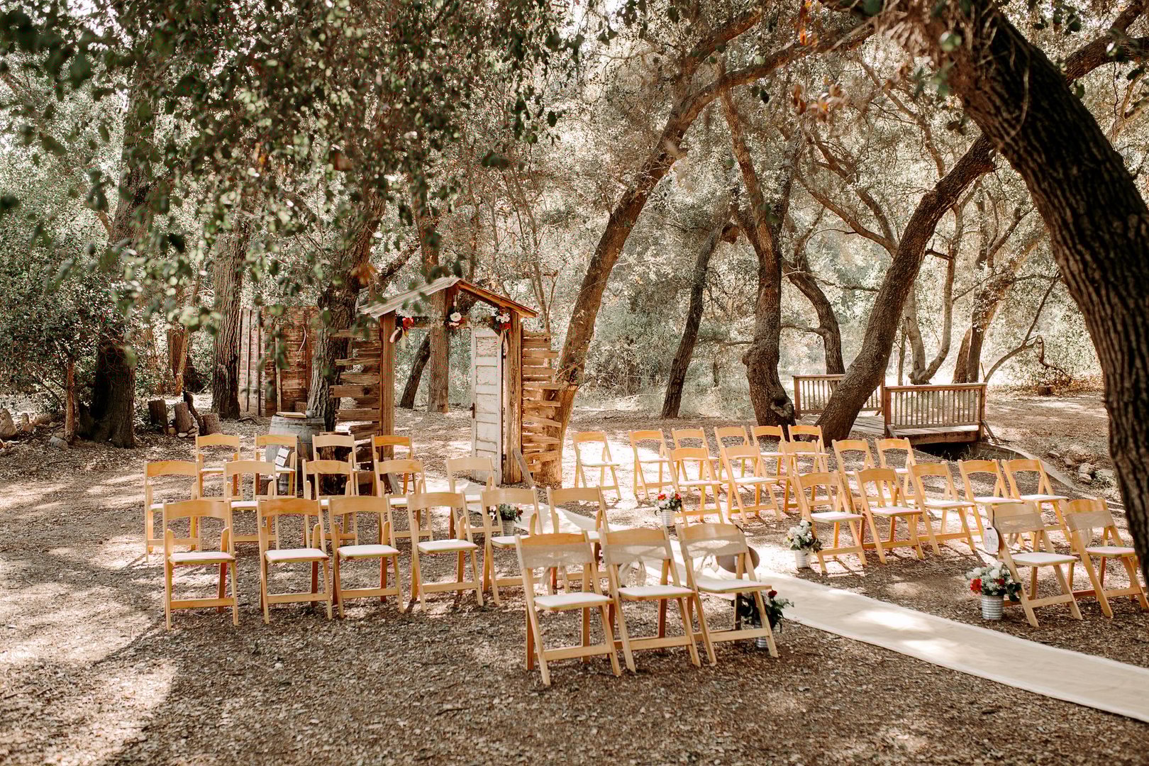 Vintage rustic venue in eucalyptus forest. Rustic wooden outdoor ceremony.
