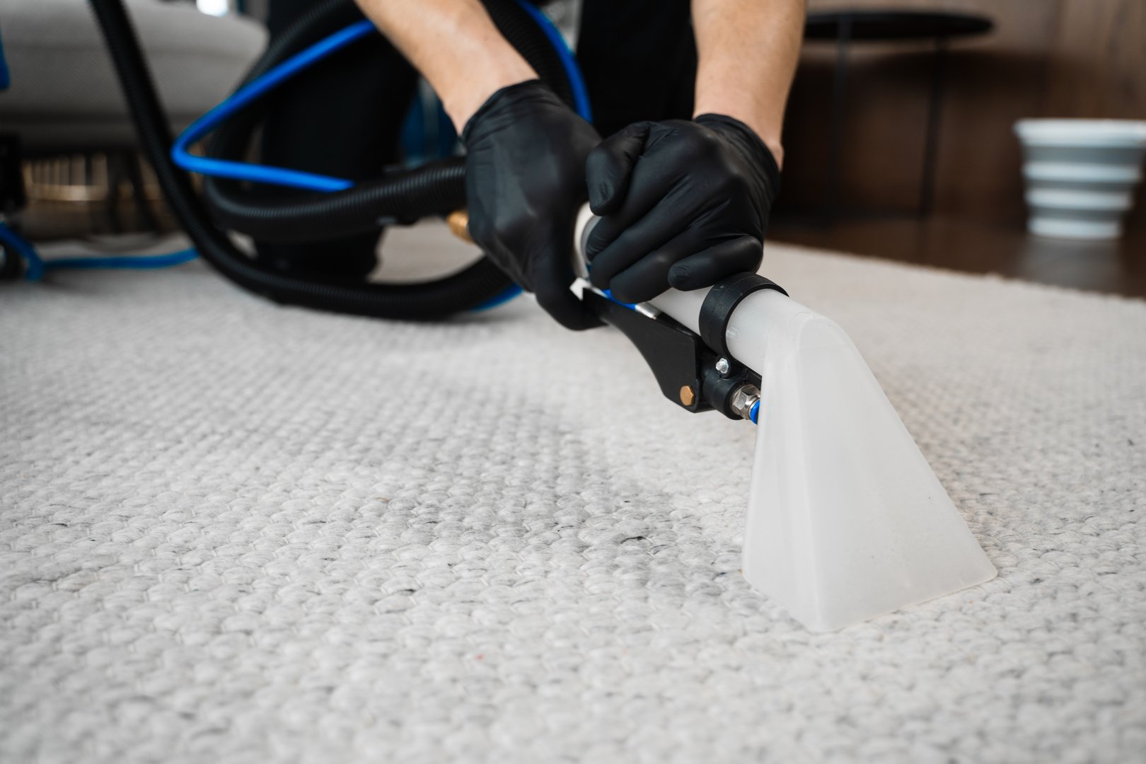 Using extractor to wash off the carpet from dust and stains. Extractor washing of carpet. Cleaner is using extractor to clean the carpet at home