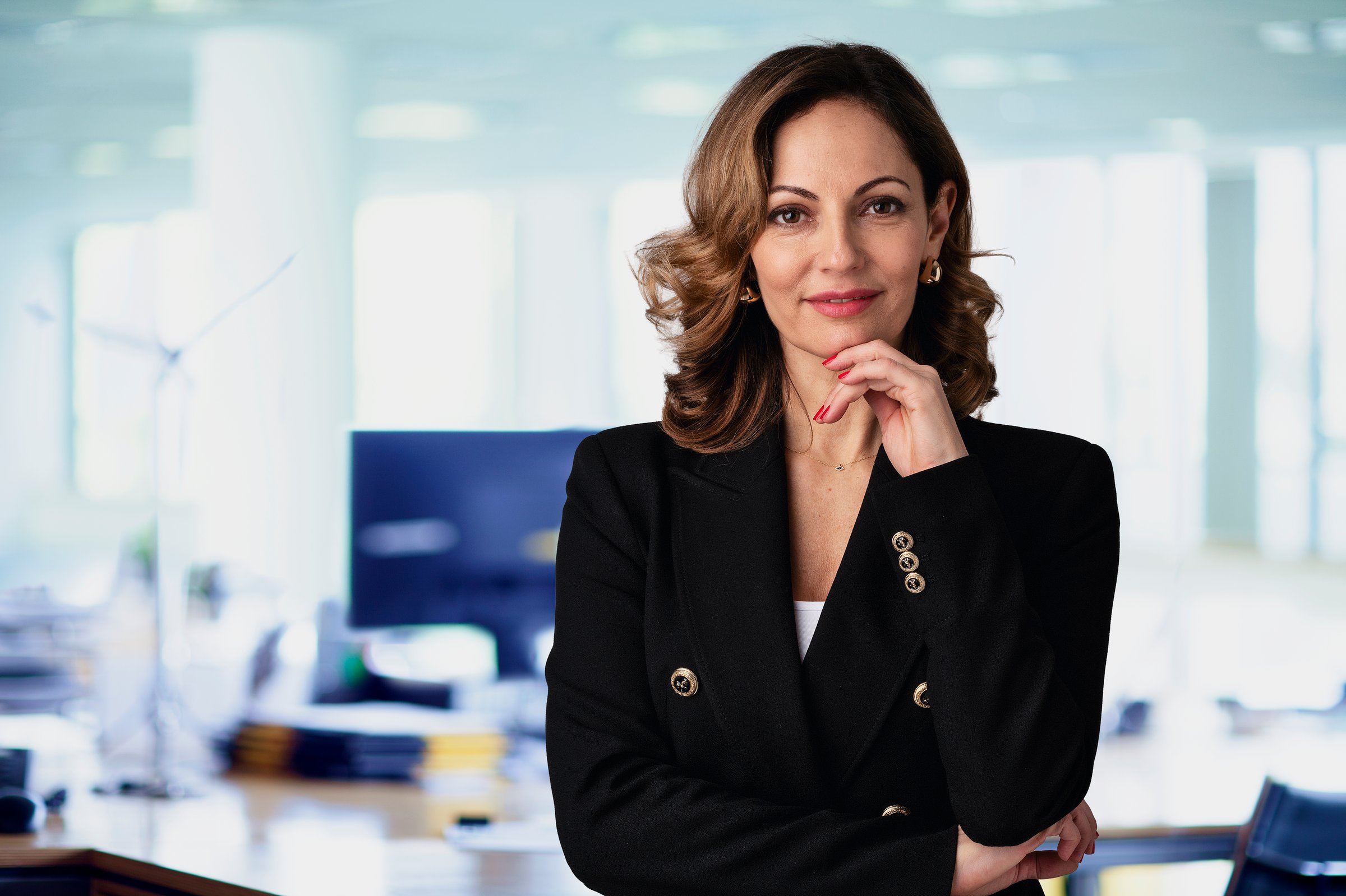Confident business woman standing at the office. Professional female wearing business casual and looking at camera.