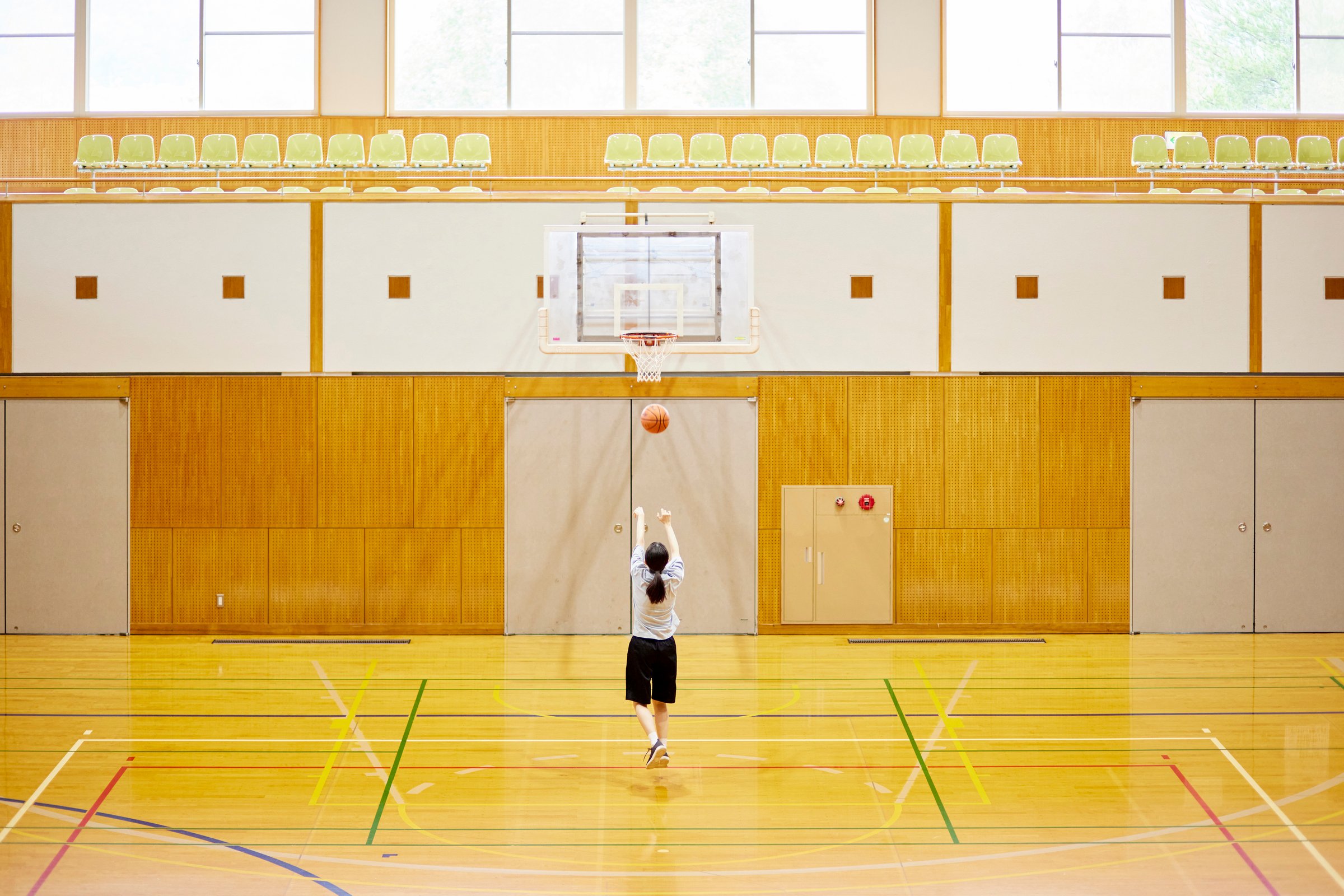Japanese woman playing basketball in the gym