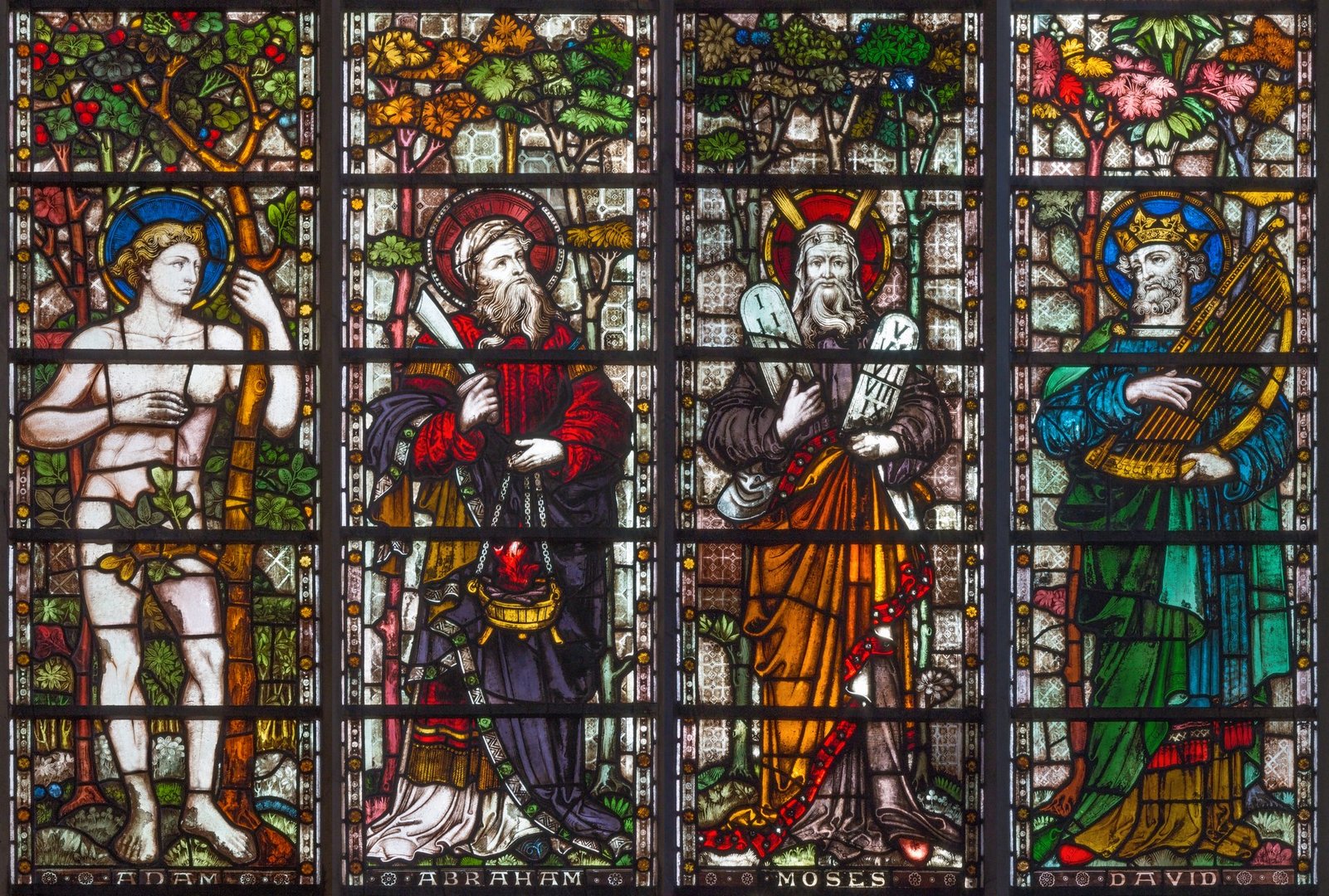 London - The patriarchs Adam, Abraham, Moses and David on the stained glass in St Mary Abbot's church on Kensington High Street.